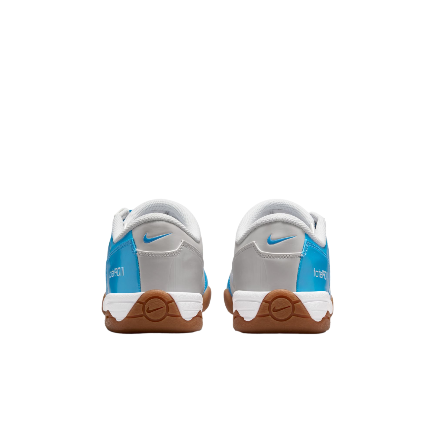 Rear view of Nike Total 90 III sneakers in light blue, grey, and white with brown gum rubber outsoles, centered against a black background.