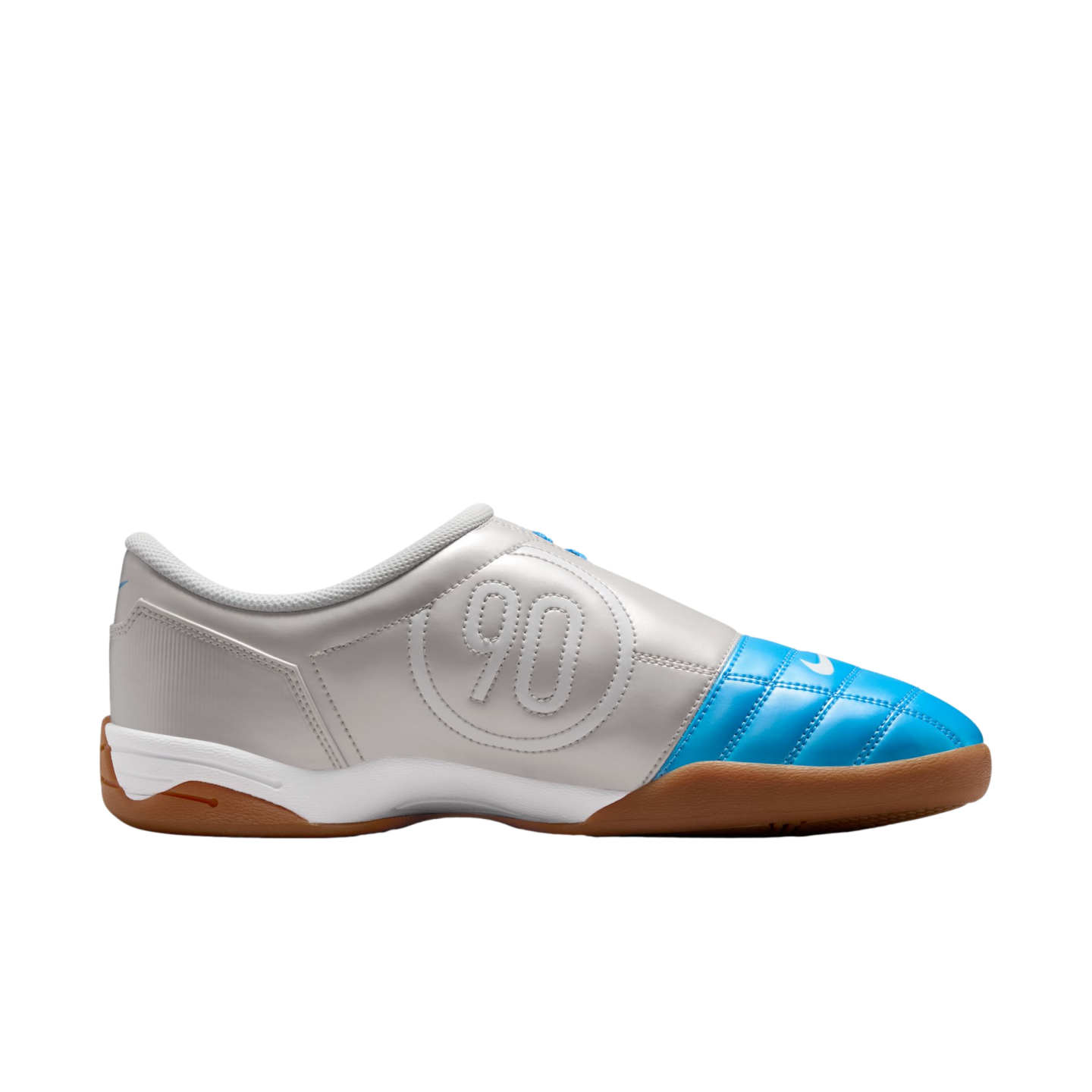 Side view of a silver Nike Total 90 indoor soccer shoe with a bright blue quilted toe, white midsole, and gum rubber sole. A large "90" logo is embossed on the side.