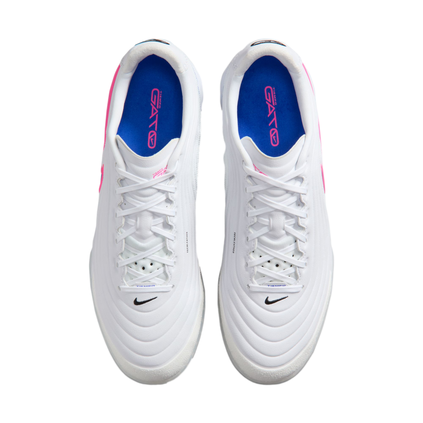 Top-down view of a pair of white Nike Tiempo Gato soccer shoes with blue insoles and pink accents on a black background.