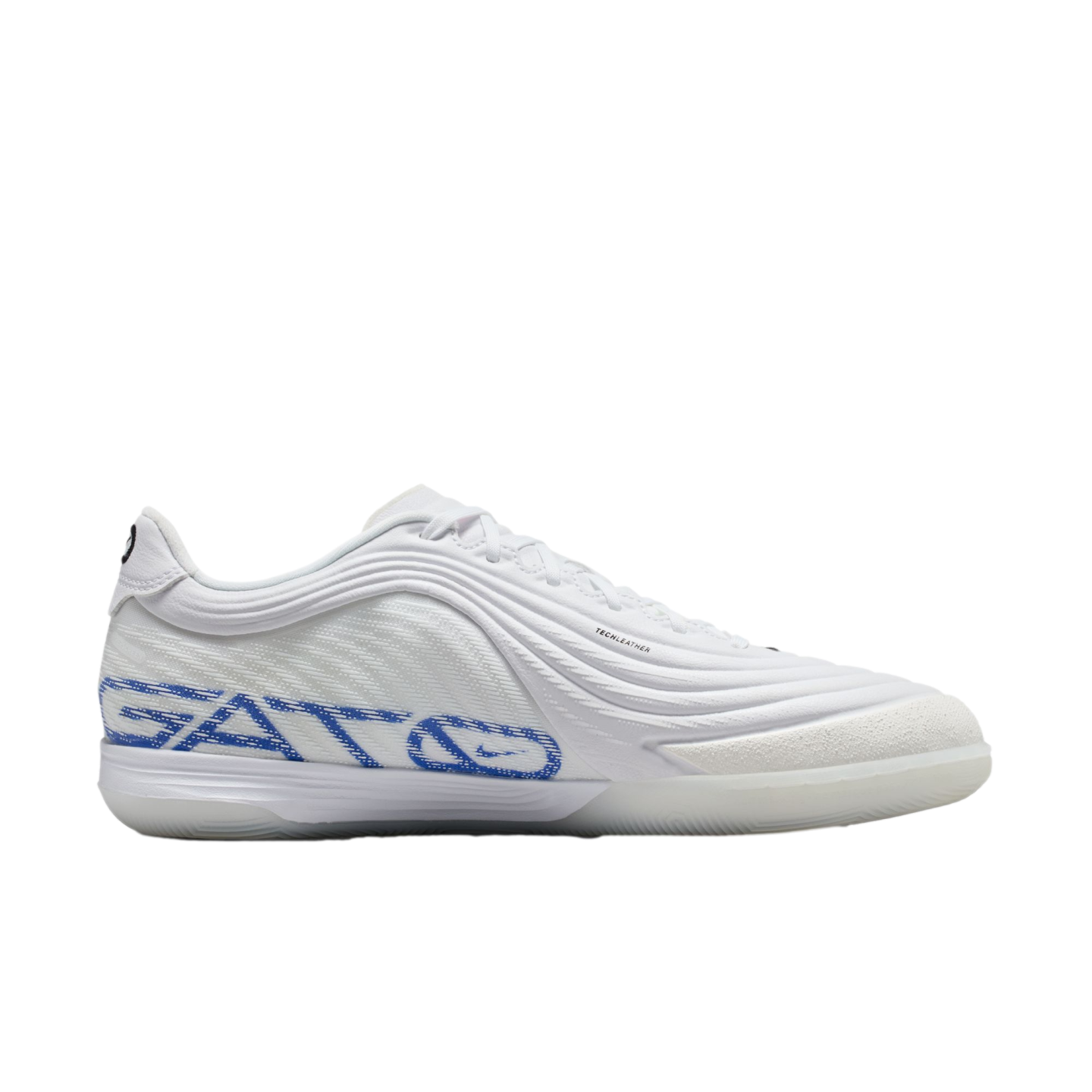 Profile view of a white indoor soccer shoe with blue "GATO" branding and a textured wavy upper on a black background.