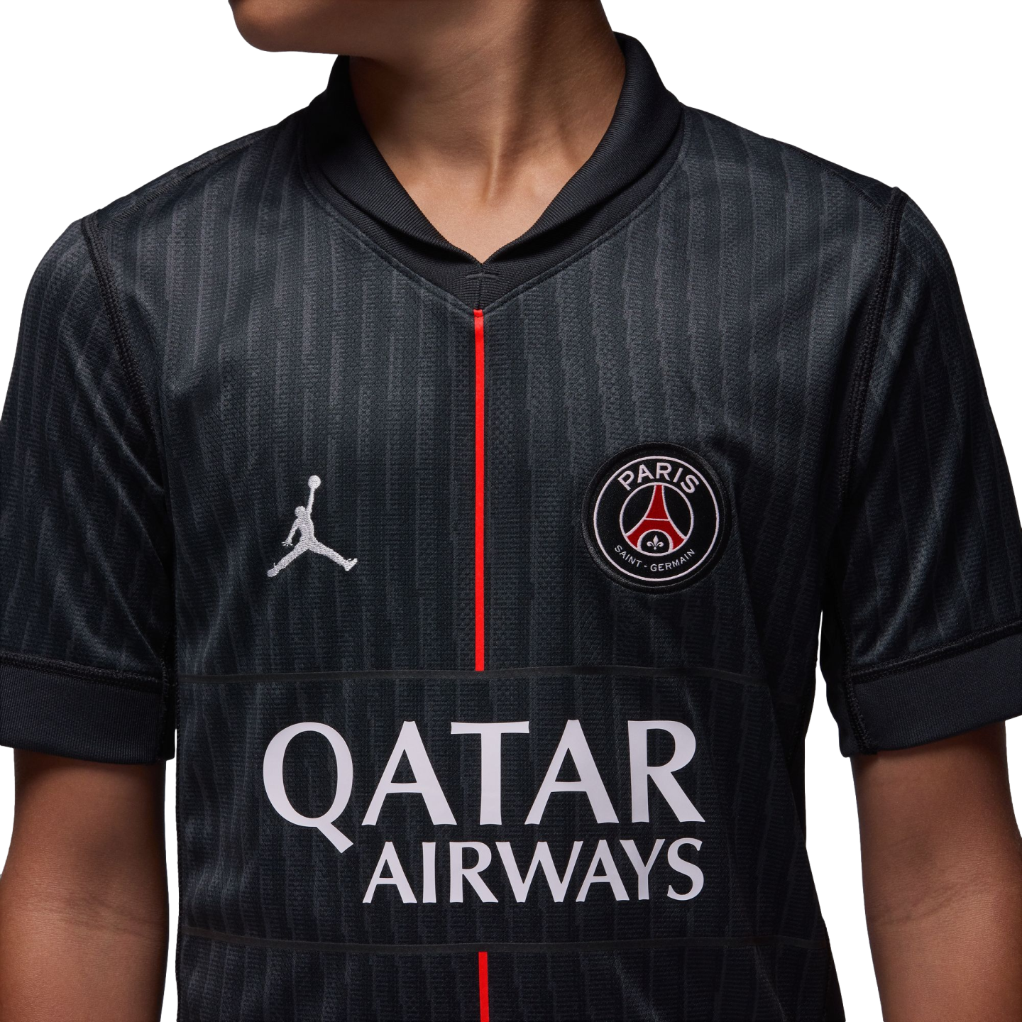 Close-up of a black Paris Saint-Germain jersey featuring the Jordan logo, PSG crest, and Qatar Airways sponsor text, with a thin red vertical line down the center.