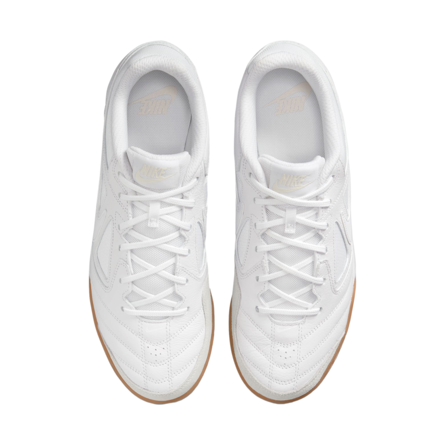 Top-down view of a pair of white Nike sneakers with gum soles, positioned against a solid black background.