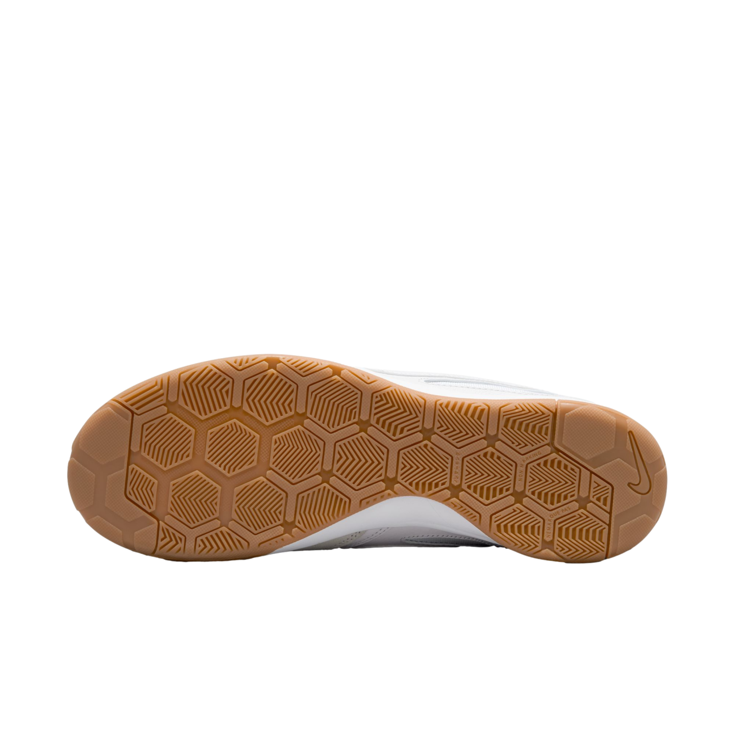 Underside of a gum rubber Nike shoe outsole with a hexagonal traction pattern against a solid black background.