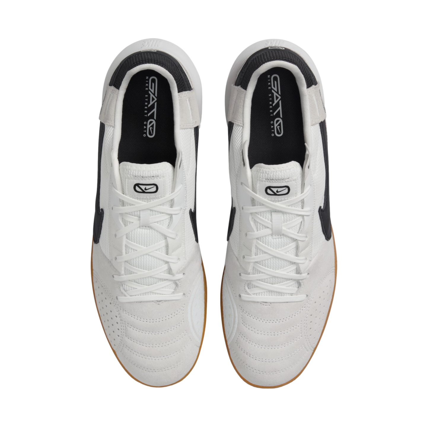 A top-down view of a pair of white and black Nike Street Gato sneakers with white laces and gum outsoles against a white background.