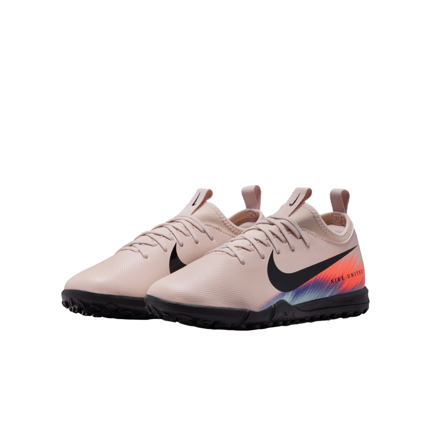 A pair of pale pink Nike United soccer turf shoes featuring a black swoosh and vibrant orange and blue gradient heel, shown against a black backdrop.