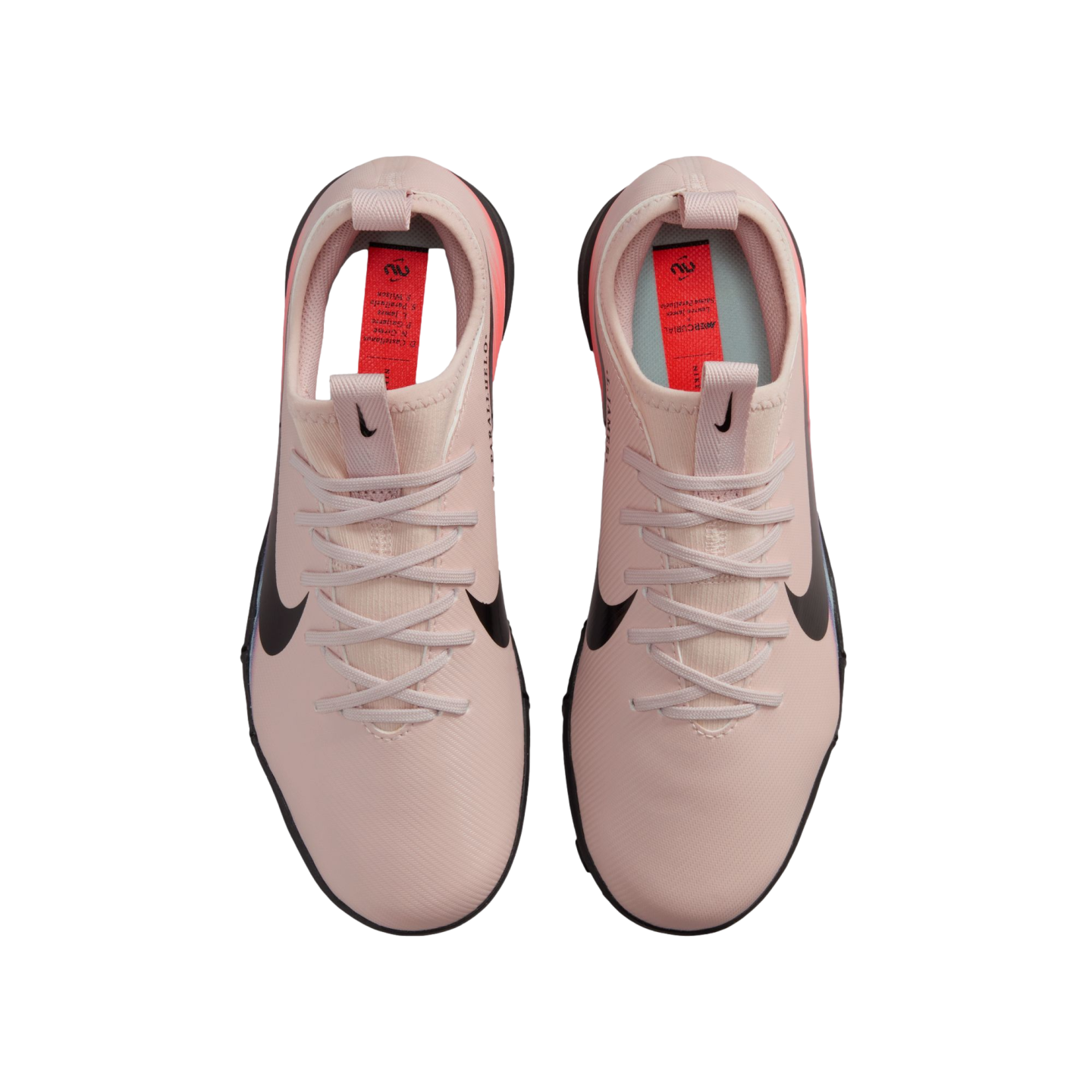 Top-down view of a pair of light pink Nike soccer shoes with black swooshes on a solid black background.