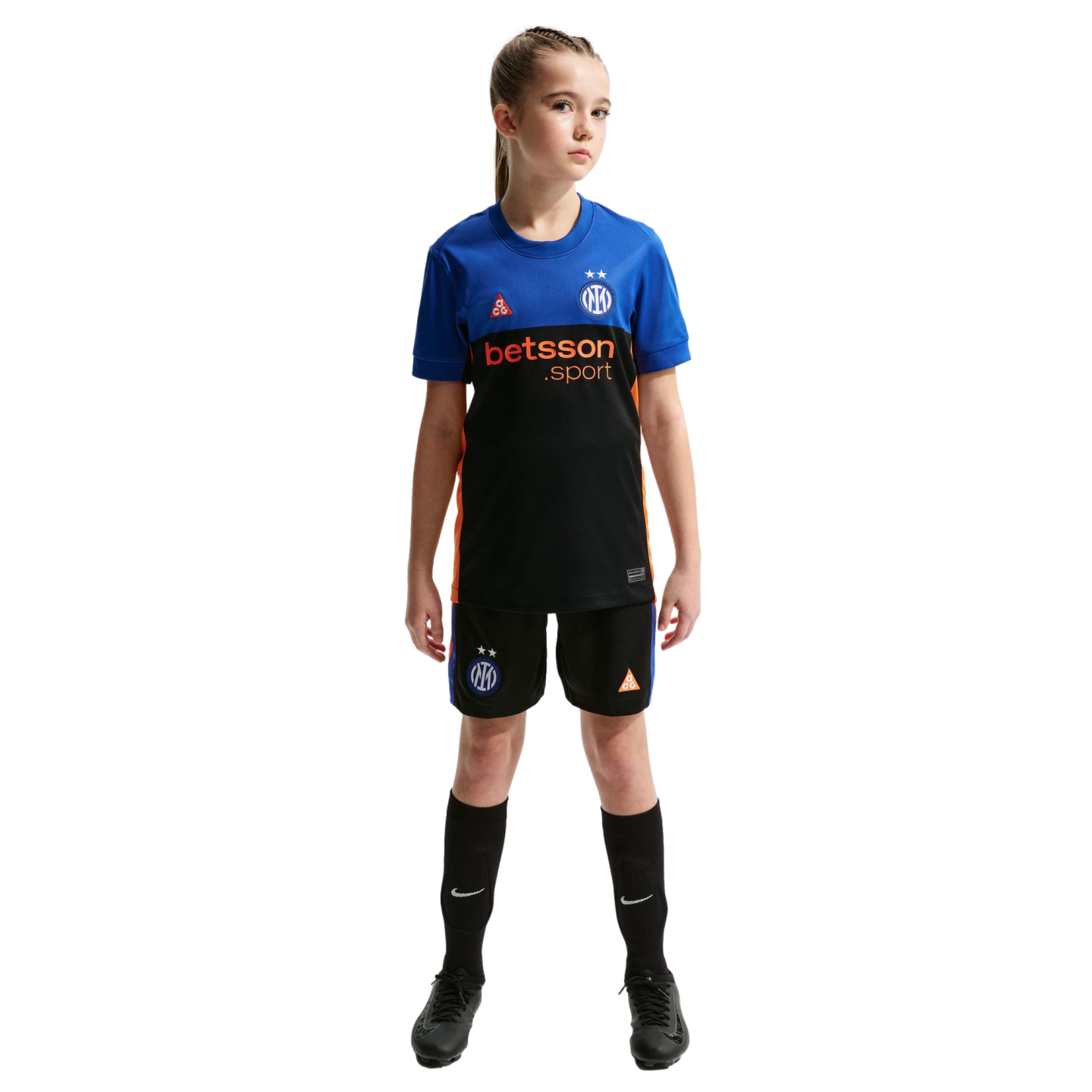 Young girl in a blue, black, and orange soccer kit featuring Inter Milan and betsson logos, standing against a black background.