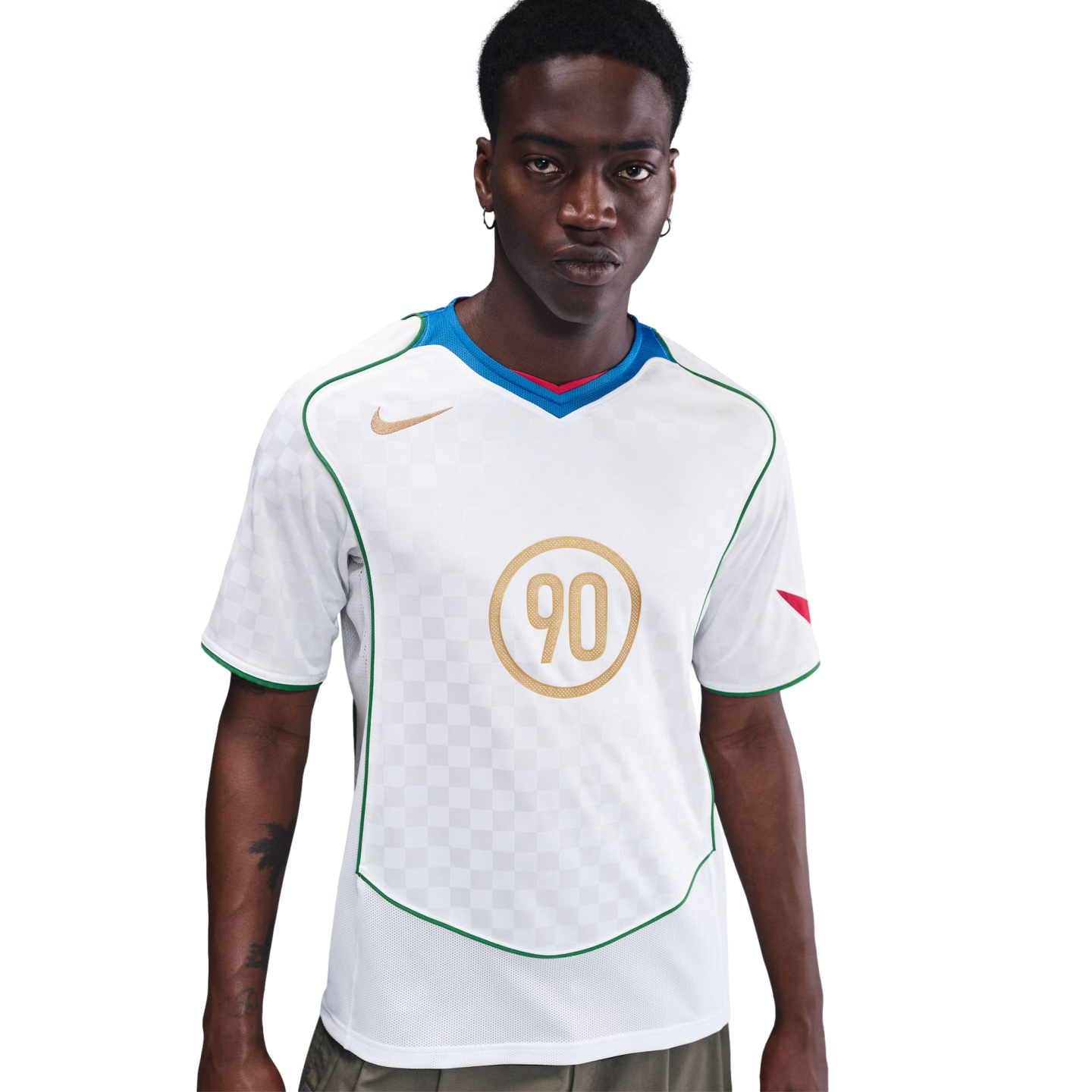 A man wears a white Nike Total 90 soccer jersey with gold accents, green trim, and a blue and red V-neck collar against a plain white background.