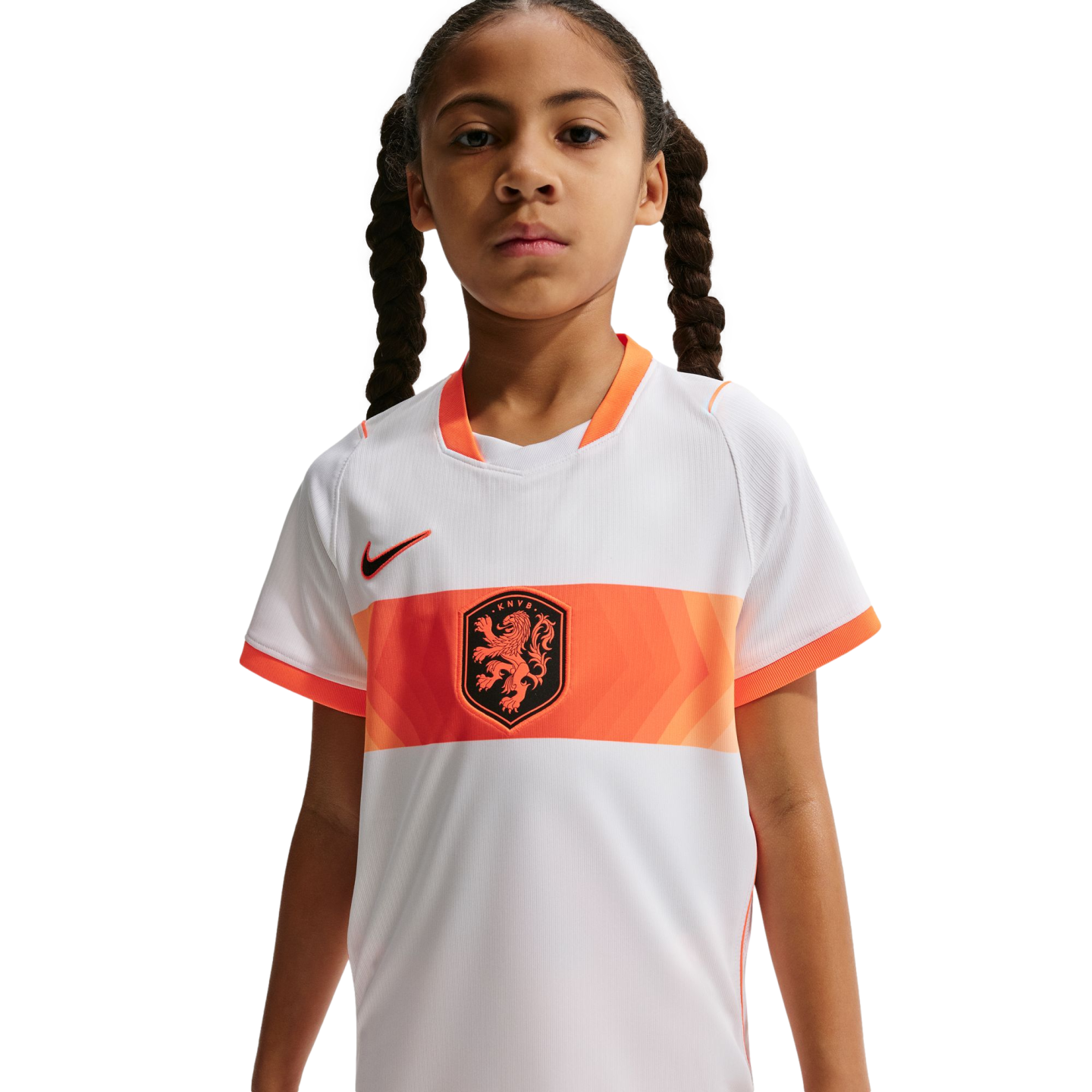 A young girl with braided hair wearing a white and orange Netherlands national team soccer jersey against a black background.
