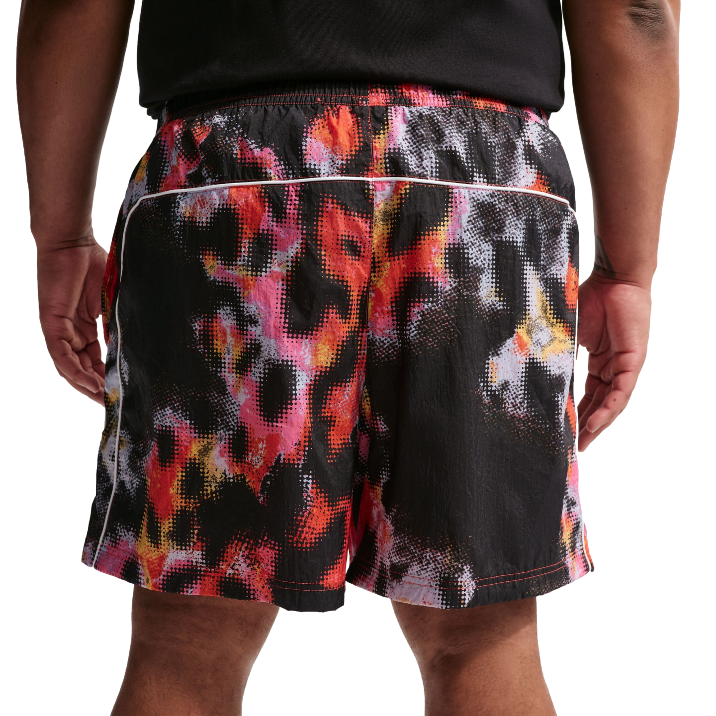 Back view of a person wearing a black shirt and shorts with a vibrant, pixelated abstract print in red, pink, orange, and white.