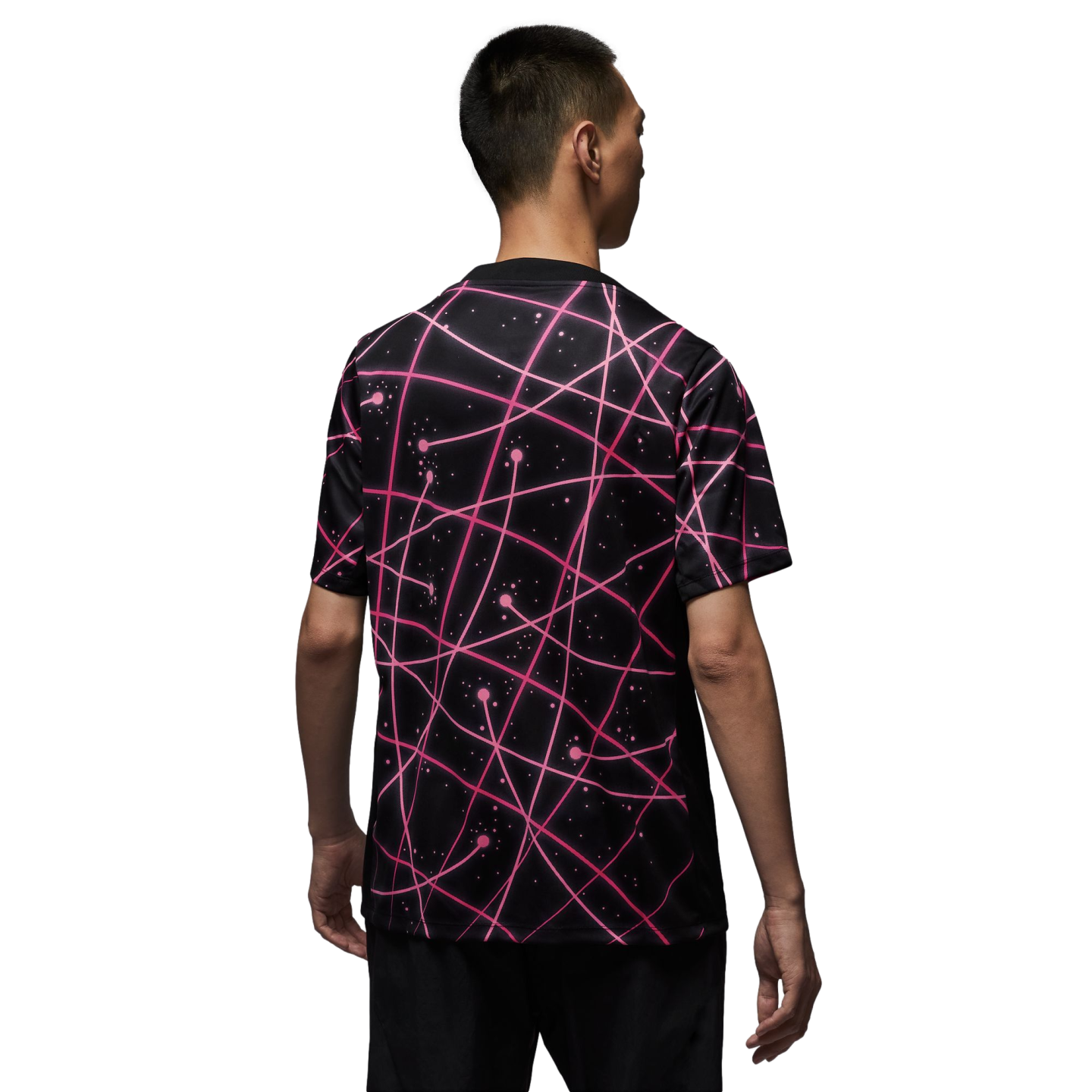 Back view of a man wearing a black t-shirt featuring an all-over pink neon geometric line and dot pattern.