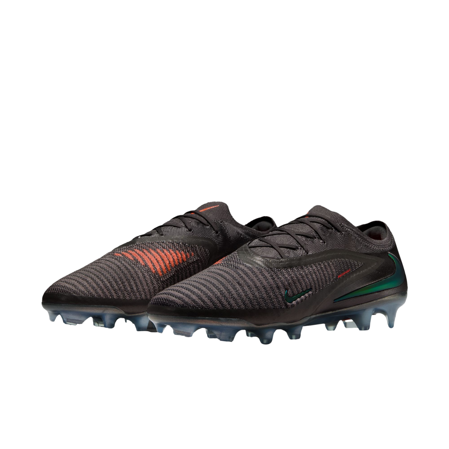 A pair of black Nike soccer cleats with orange accents and iridescent green swooshes against a black background.