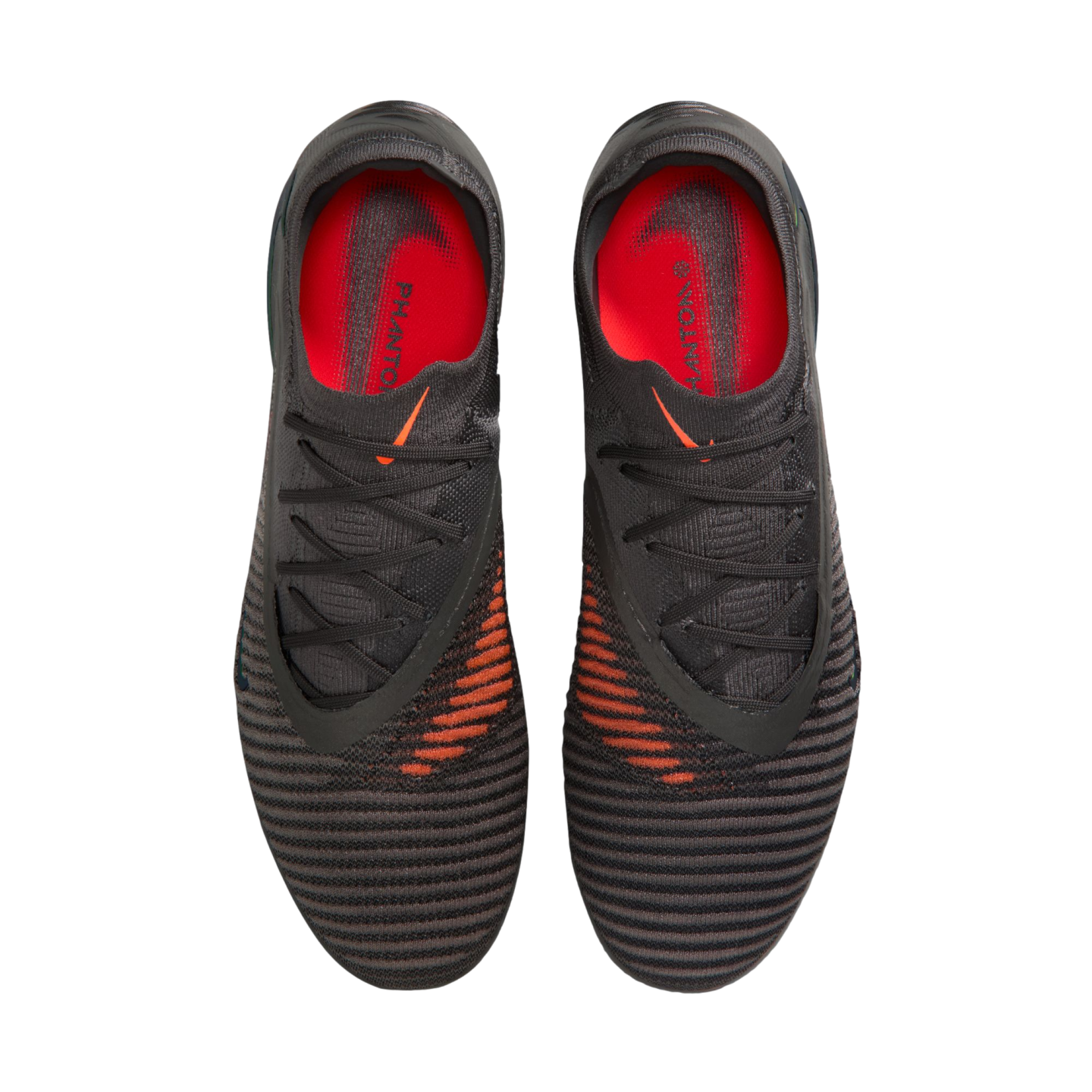 Top-down view of black and grey Nike Phantom soccer cleats featuring orange accents and insoles, set against a black background.
