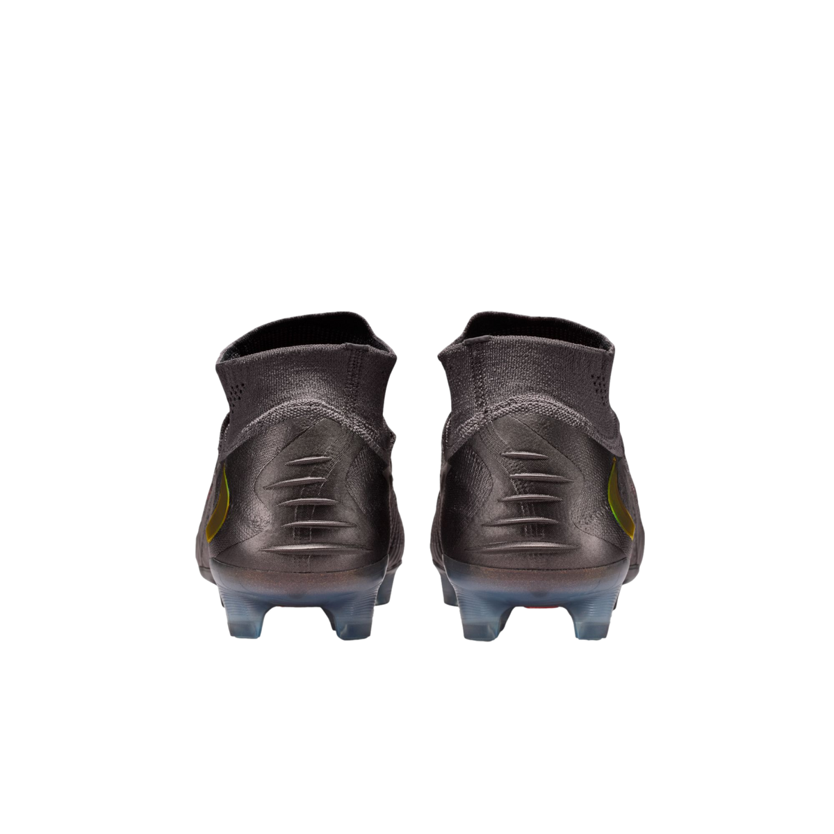 A rear view of a pair of dark grey soccer cleats with high-top knit collars, featuring five horizontal ridges on each heel and translucent studs, set against a solid black background.