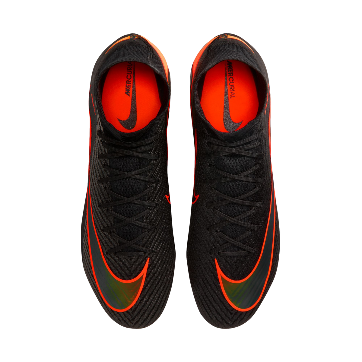 An overhead view of a pair of black Nike Mercurial soccer cleats with vibrant orange accents and black laces, set against a solid black background. The shoes feature large orange swooshes on the forefoot and bright orange interior linings with "MERCURIAL"