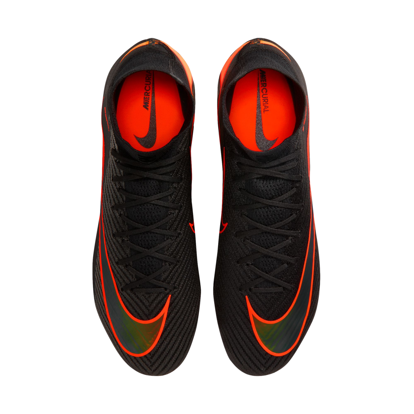 An overhead view of a pair of black Nike Mercurial soccer cleats with vibrant orange accents and black laces, set against a solid black background. The shoes feature large orange swooshes on the forefoot and bright orange interior linings with "MERCURIAL"