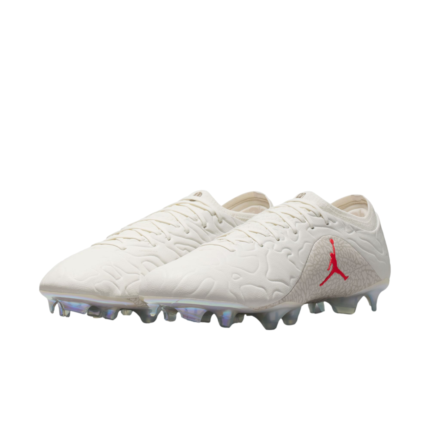 A pair of off-white Jordan Brand soccer cleats featuring a red Jumpman logo, elephant print accents, and iridescent studs against a white background.