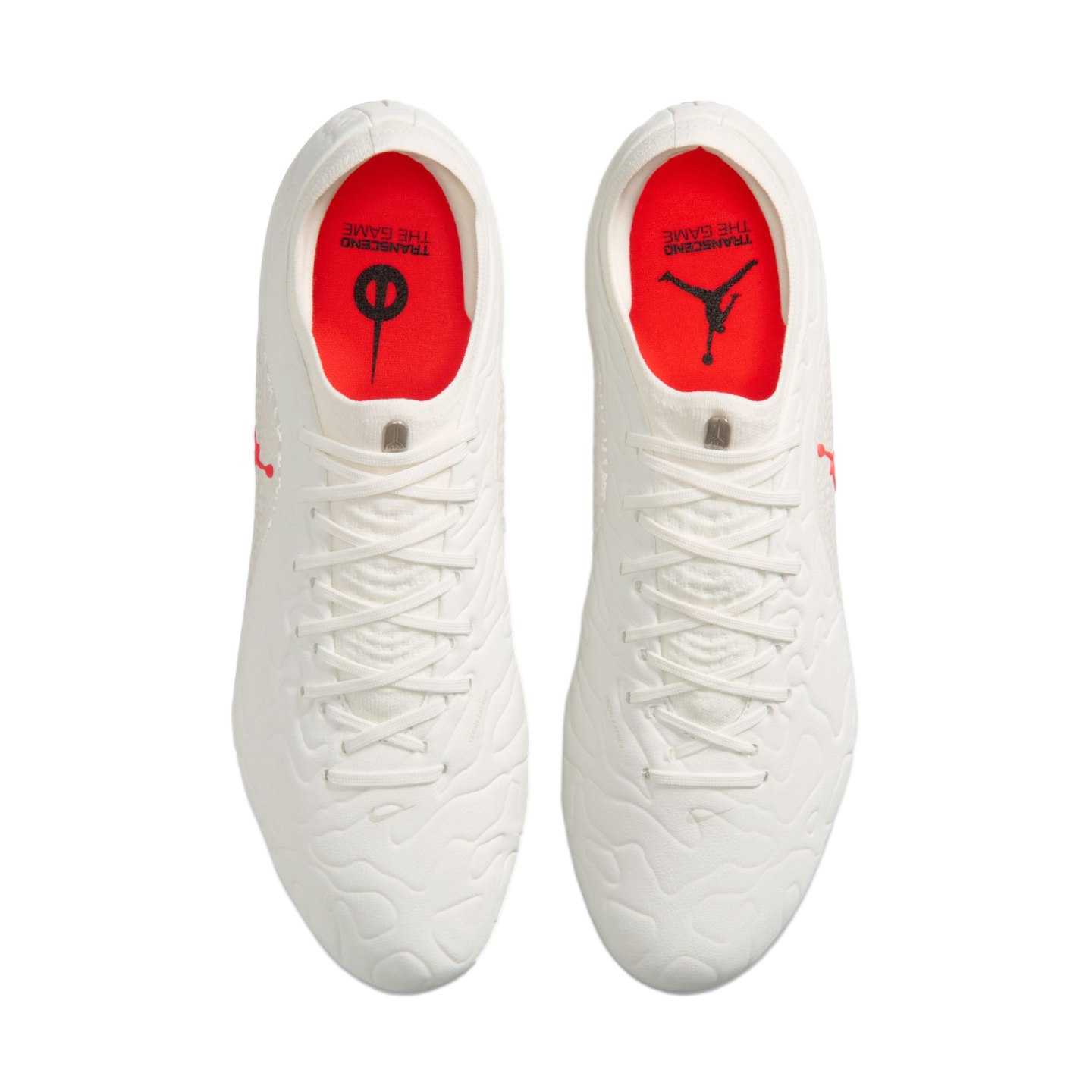 Top-down view of white soccer cleats with red insoles featuring Jumpman and Nike logos, isolated on a white background.
