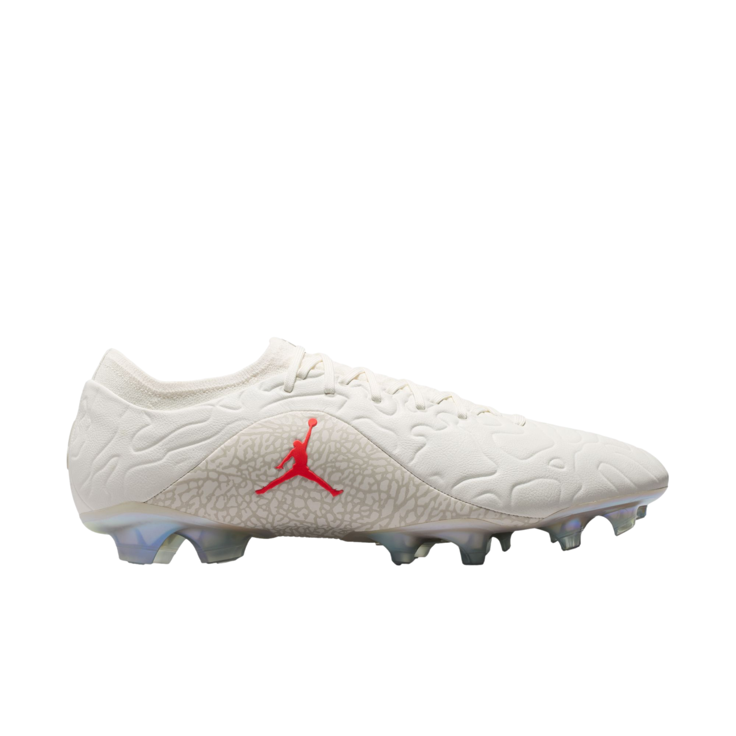 Side view of an off-white Jordan soccer cleat with a red Jumpman logo on a grey patterned midfoot and translucent studs.