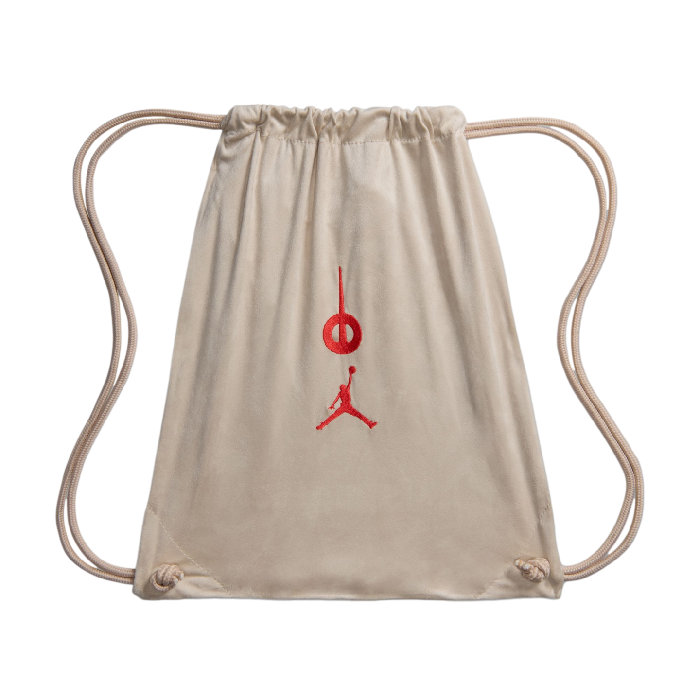 Beige suede drawstring backpack with thin rope straps. Features red embroidered Jordan Brand Jumpman and circular logos on the front center.