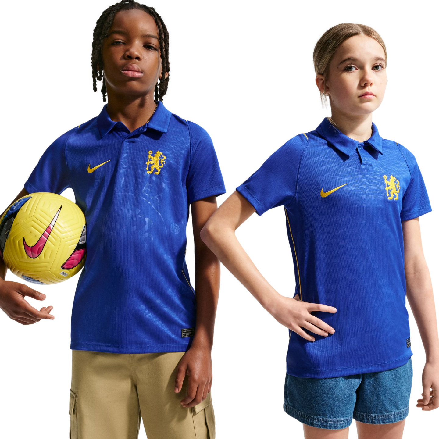 Two children wearing blue Nike Chelsea FC polo jerseys pose against a white background. The boy on the left holds a yellow soccer ball.