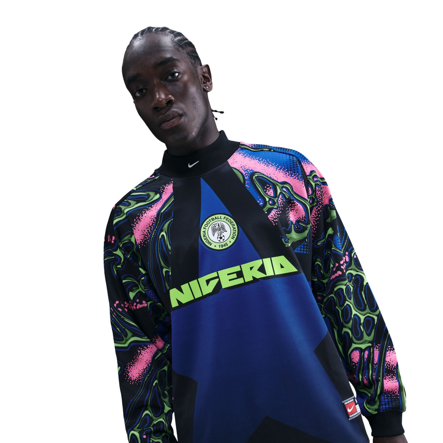 A person wearing a vibrant Nike Nigeria soccer jersey with pink, blue, and lime green patterns against a black background.