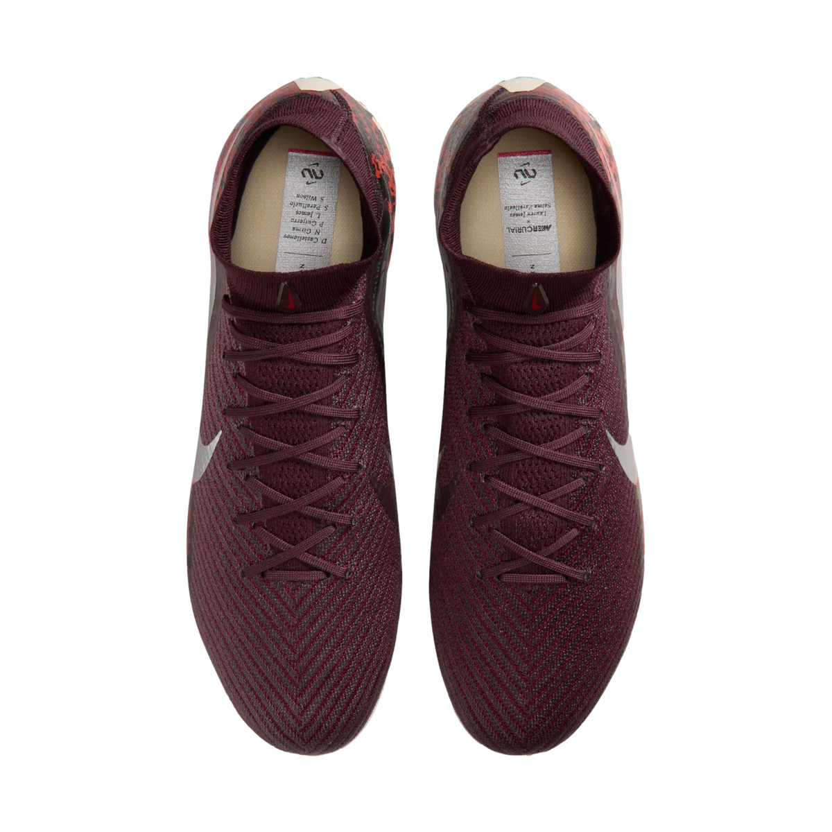 A top-down view of a pair of maroon Nike soccer cleats with a textured pattern and matching laces, set against a black background.