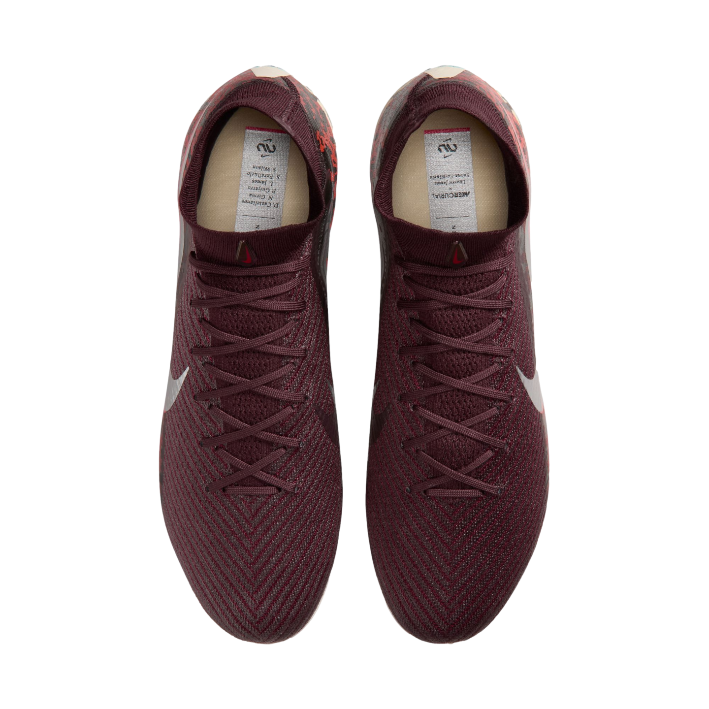 A top-down view of a pair of maroon Nike soccer cleats with a textured pattern and matching laces, set against a black background.