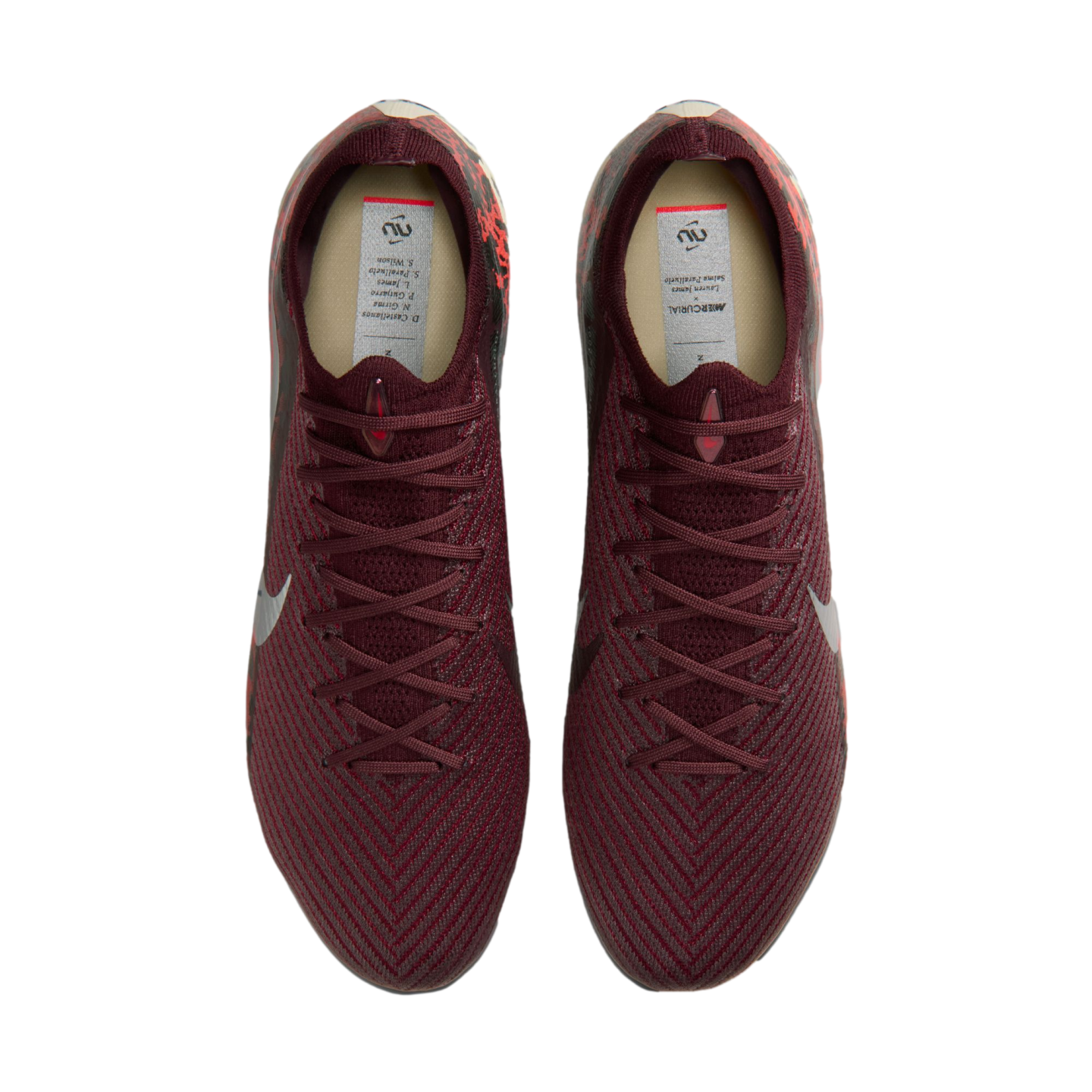 A top-down view of a pair of maroon Nike soccer cleats with a textured, knitted upper against a solid black background.