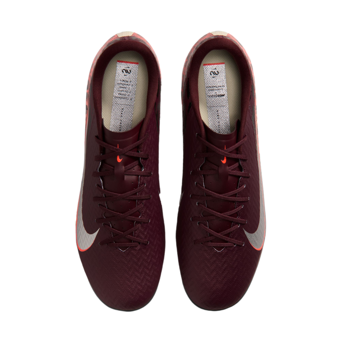 A top-down view of a pair of burgundy Nike Mercurial soccer cleats with silver Nike swooshes and orange accents, set against a black background.
