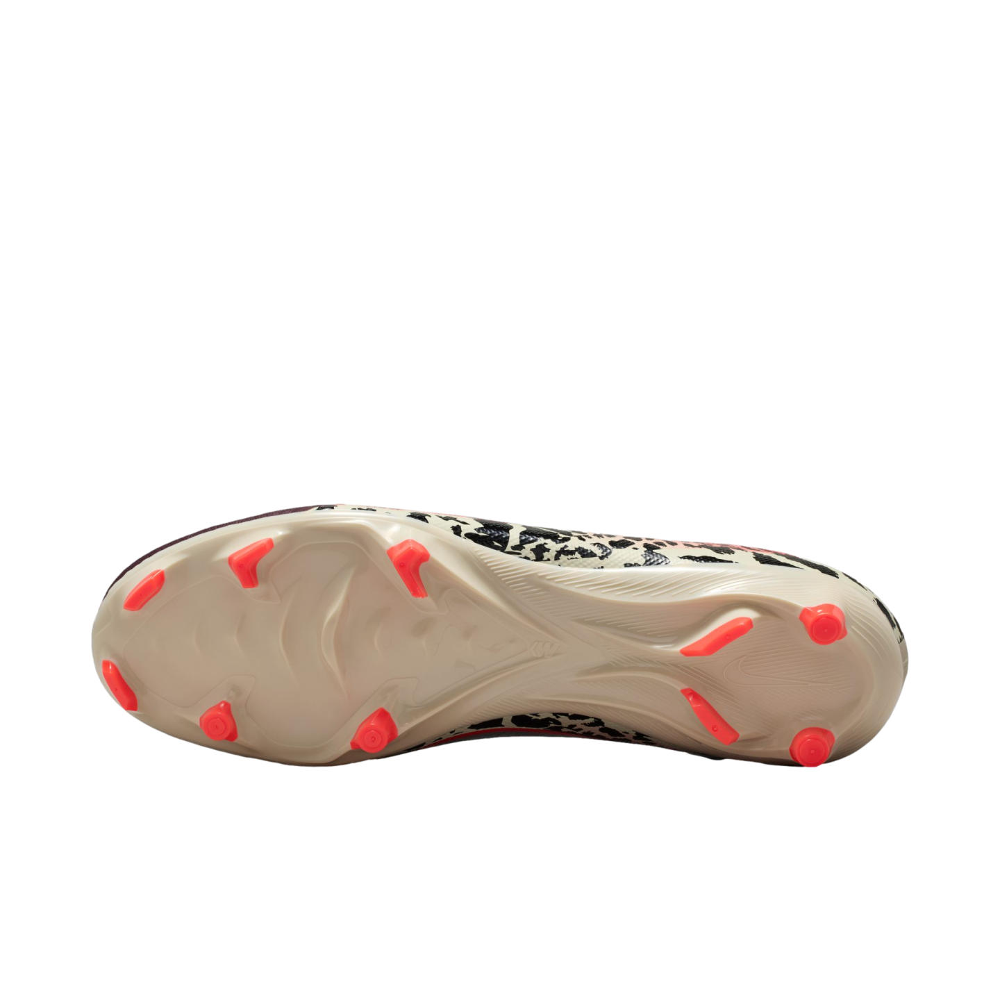 An underside view of a cream-colored soccer cleat featuring bright neon orange studs, showing a black and white abstract graphic pattern along the edges against a solid black background.