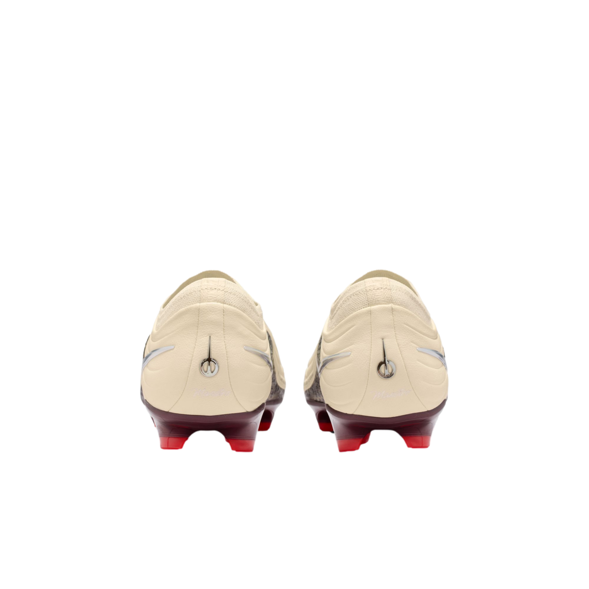 A rear view of a pair of cream-colored soccer cleats with maroon heel plates and bright red studs, set against a solid black background.