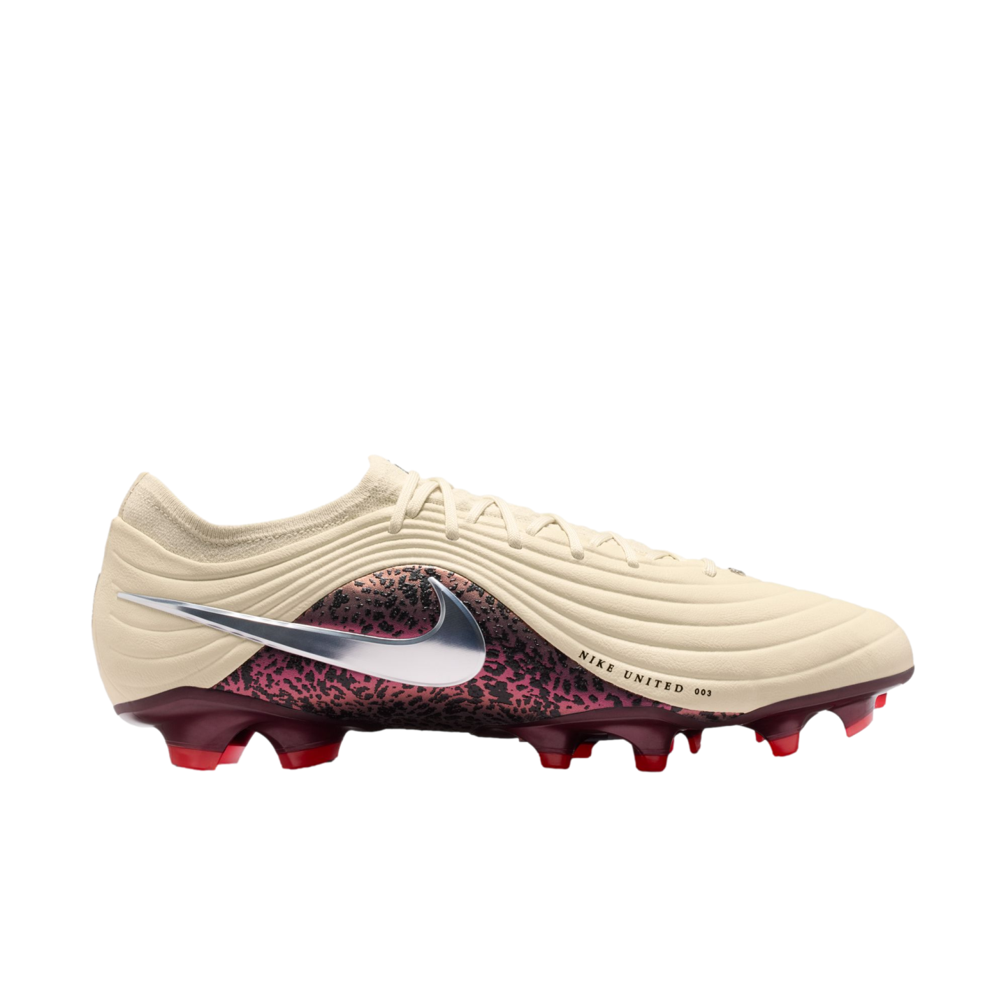 A side-profile view of a Nike soccer cleat featuring a cream-colored ridged upper, a large silver Swoosh over a maroon and black patterned midsection, and a maroon soleplate with red studs against a black background.