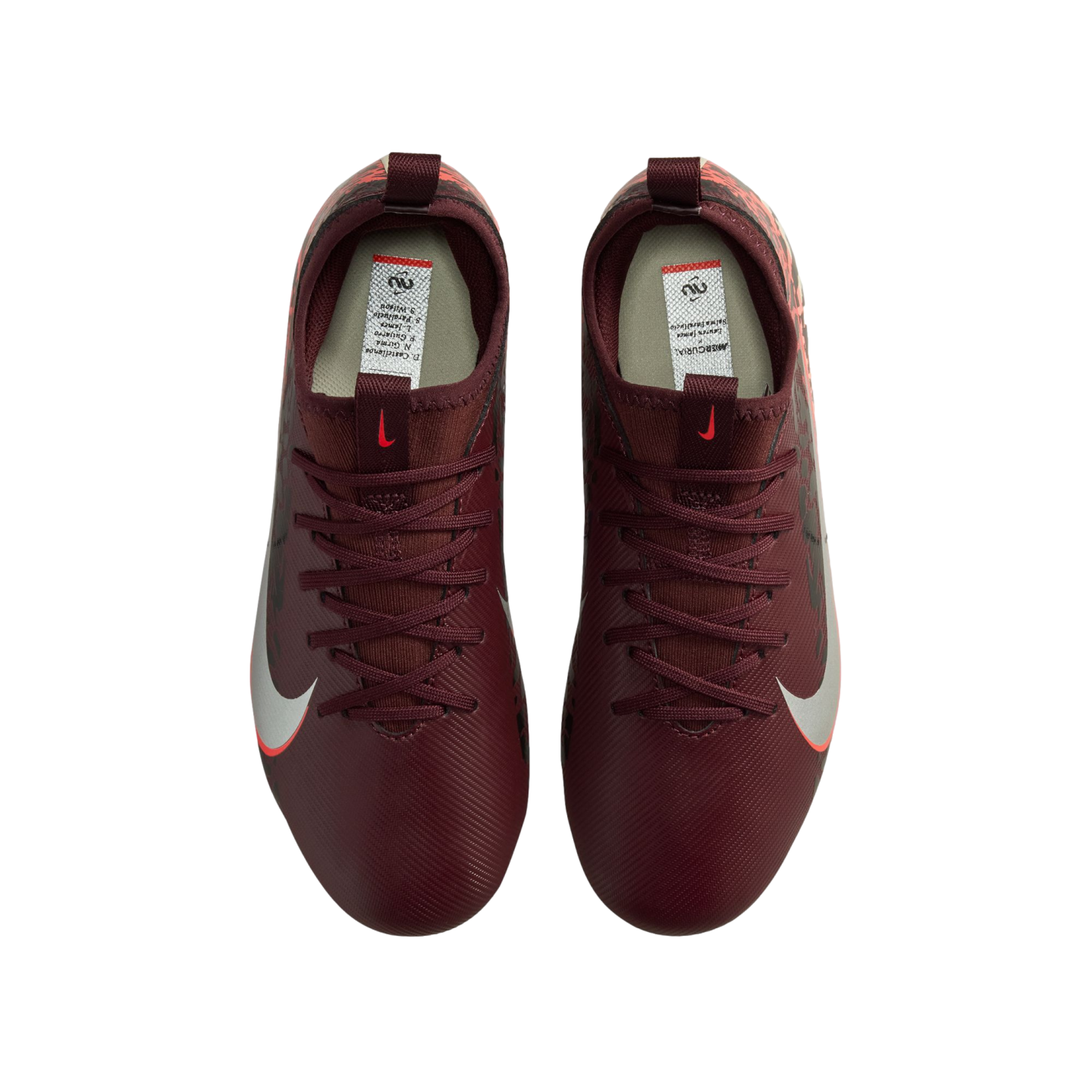 A top-down view of a pair of burgundy Nike soccer cleats against a black background. The cleats feature maroon laces and a white Nike swoosh with a red outline on the sides.