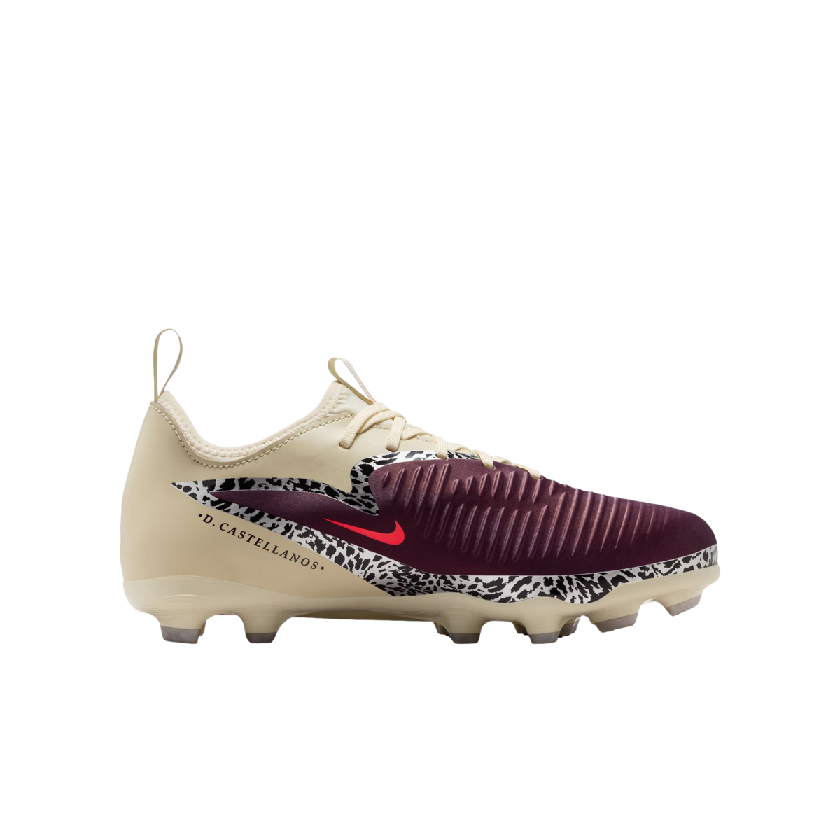A profile view of a Nike soccer cleat against a solid black background. The shoe features a cream-colored upper, a maroon ribbed toe, and a black-and-white speckled pattern across the mid-section with a small red Nike swoosh. The name ".D. CASTELLANOS." i