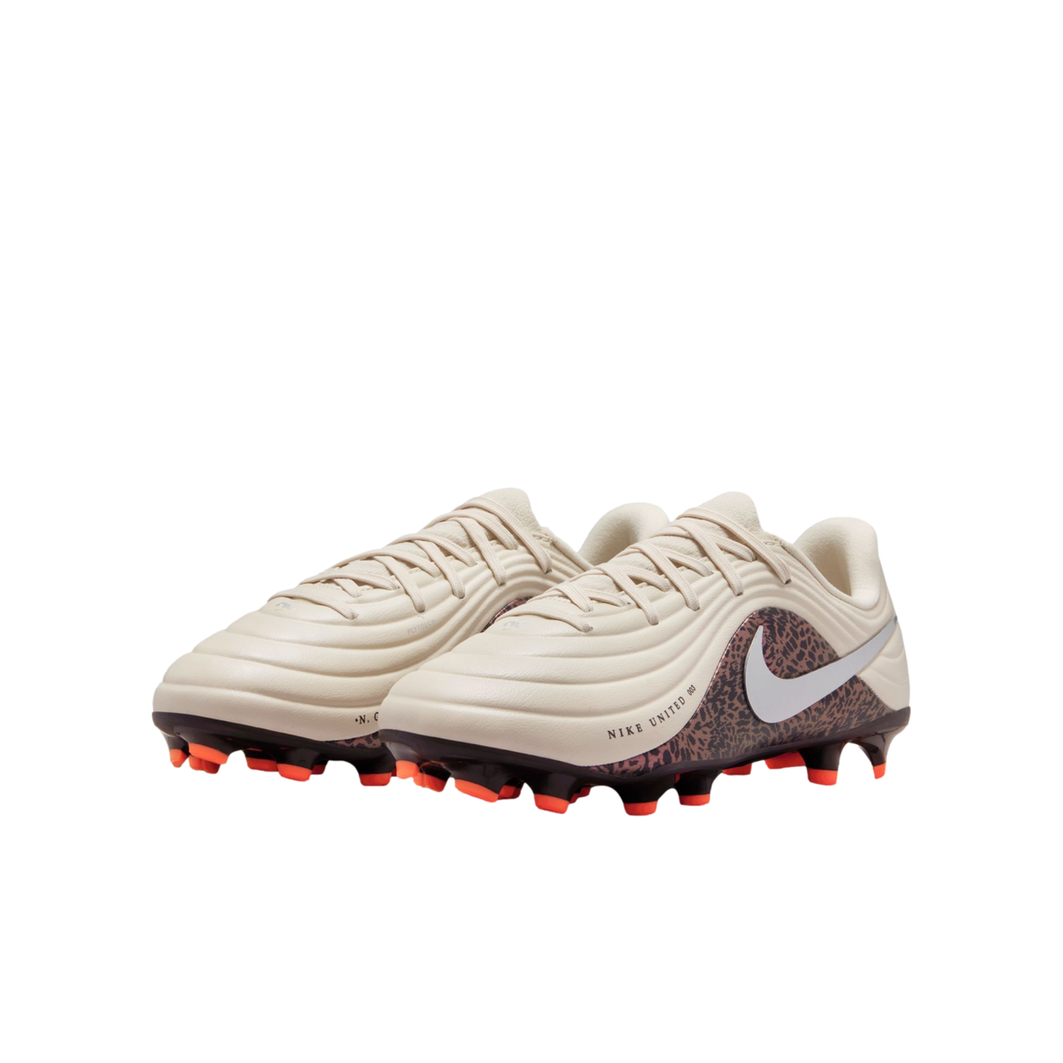 A pair of off-white Nike soccer cleats featuring a leopard print design on the heel and bright orange studs, set against a solid black background.