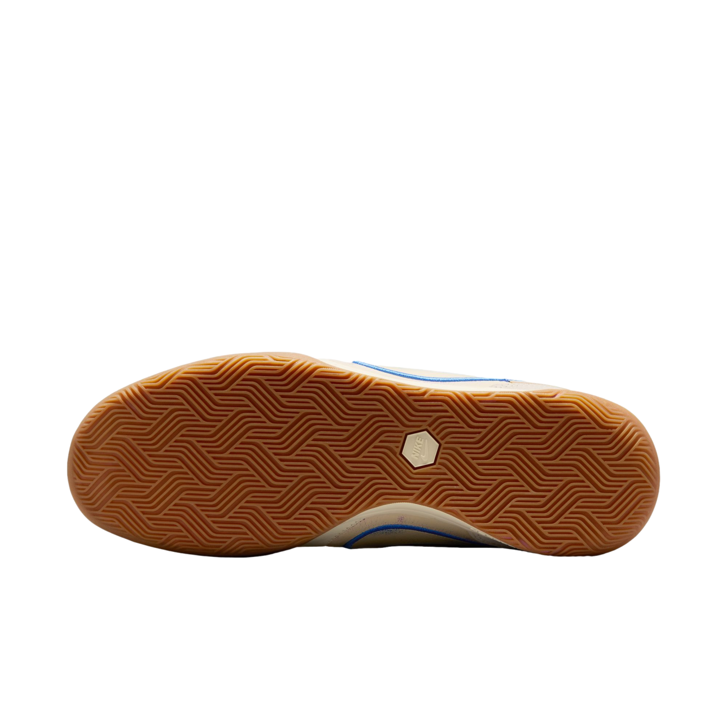 A view of the gum rubber outsole of a shoe against a black background, featuring an intricate herringbone tread pattern and a white hexagonal Nike logo in the center.