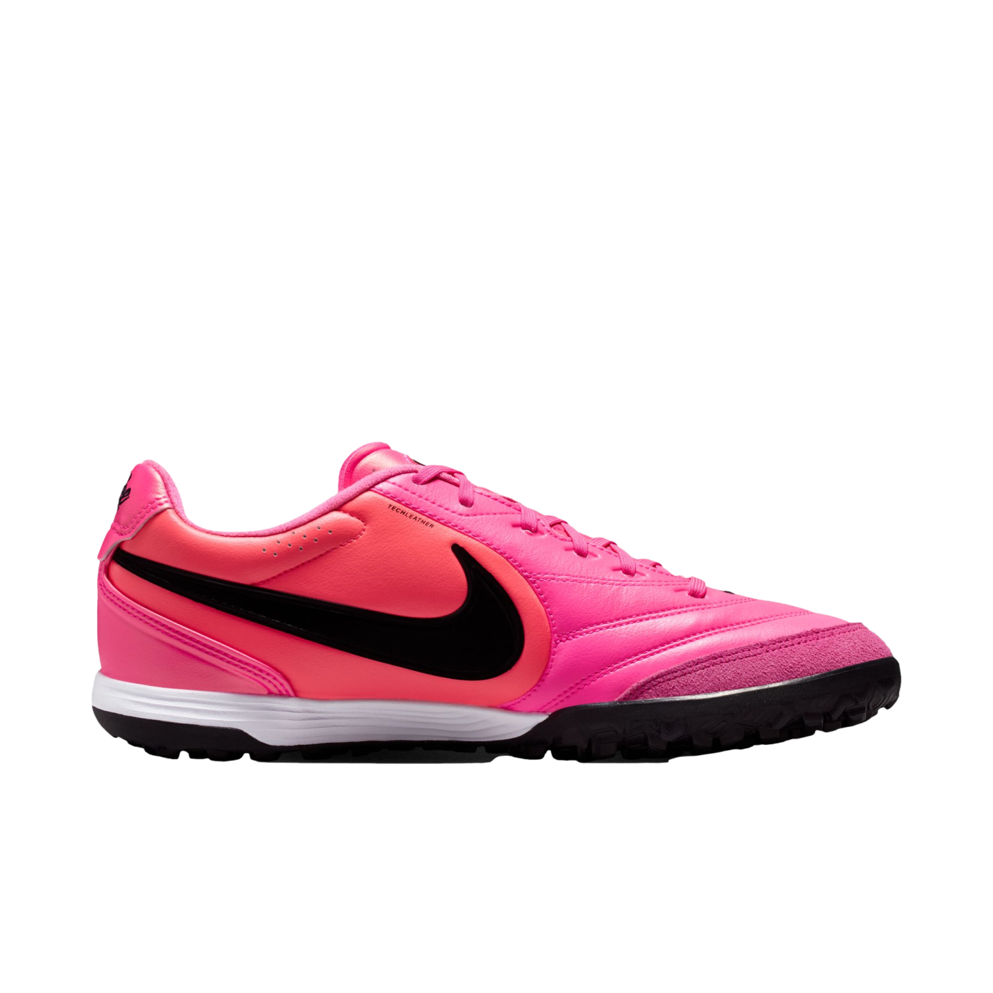 A side view of a bright pink Nike soccer turf shoe with a black Swoosh and white midsole, isolated against a white background.