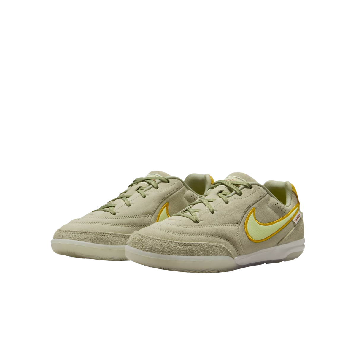 Pale green Nike Tiempo indoor soccer shoes with yellow accents on a solid black background.