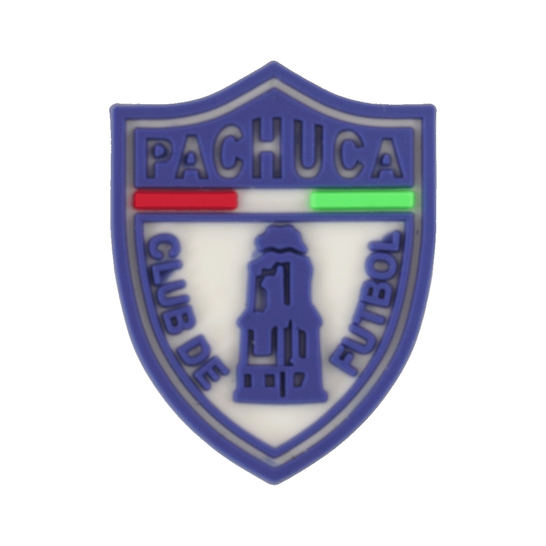 A soccer croc charm shaped like the blue and white shield crest of the Pachuca soccer club, featuring a central monument silhouette and red and green accents.