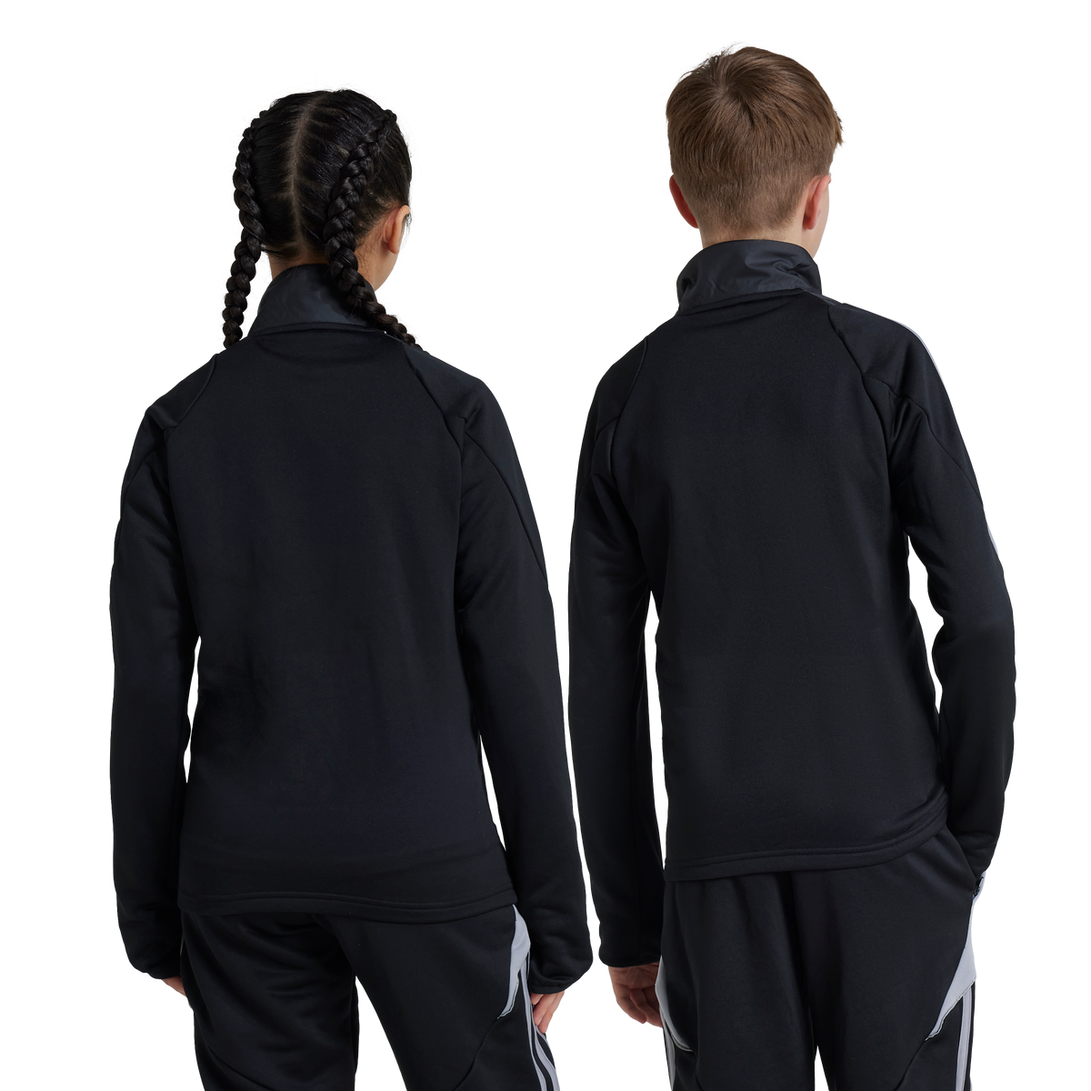 Back view of two children, a girl with braided hair and a boy, wearing matching black athletic tracksuits against a white background.