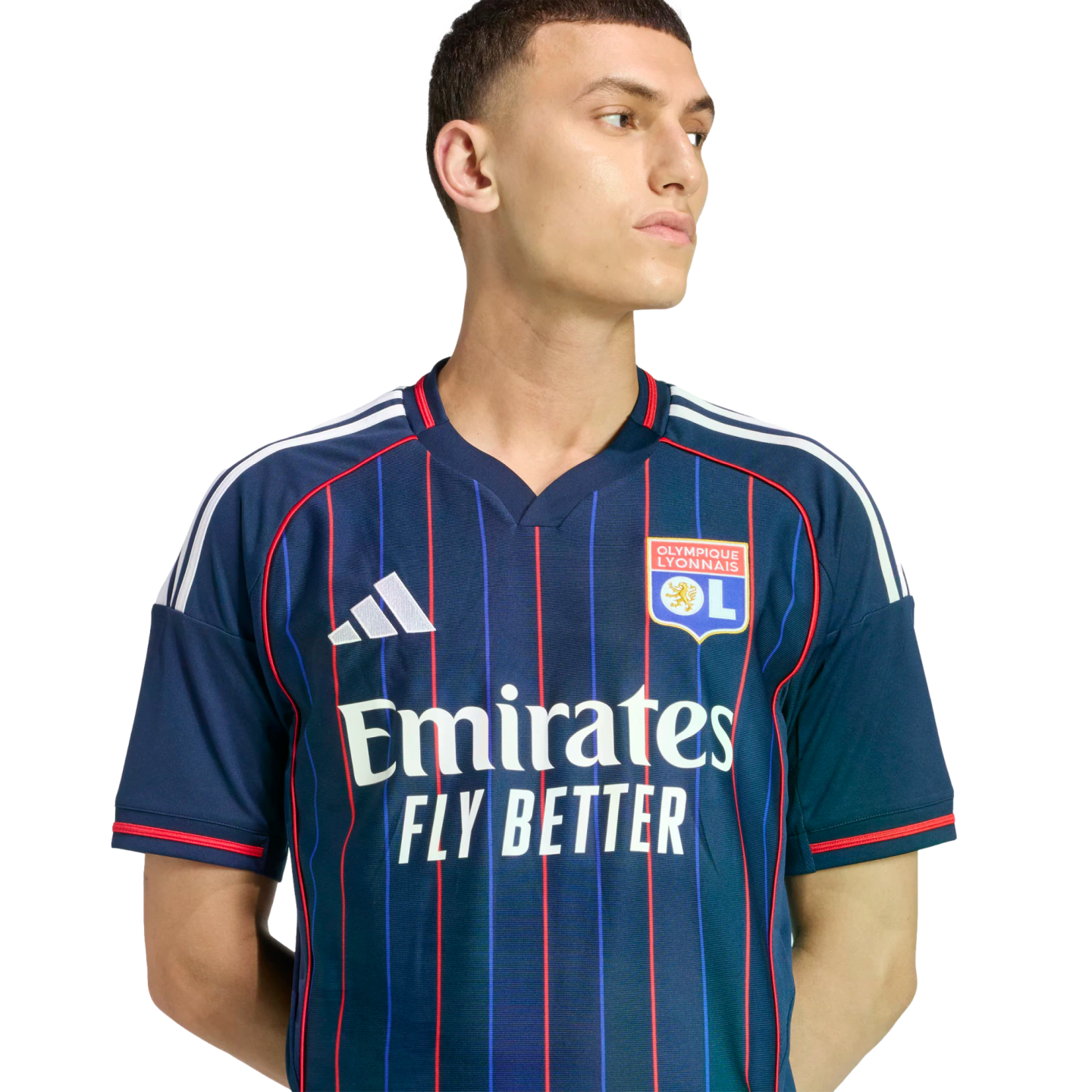 Male model wearing a navy blue Olympique Lyonnais soccer jersey with thin red stripes and white Adidas and Emirates logos.
