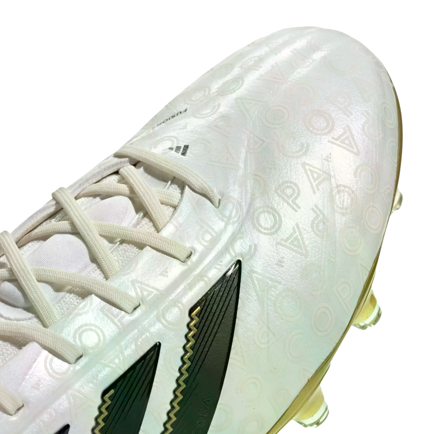 Close-up of a white Adidas Copa soccer cleat with an iridescent finish and embossed "COPA" pattern. It features white laces and dark, angular side stripes.