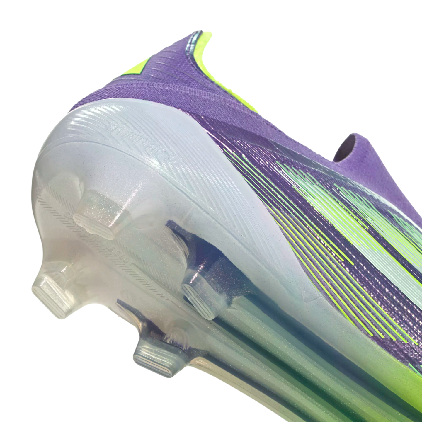 Close-up of a purple and lime green soccer cleat heel and translucent sole against a black background.