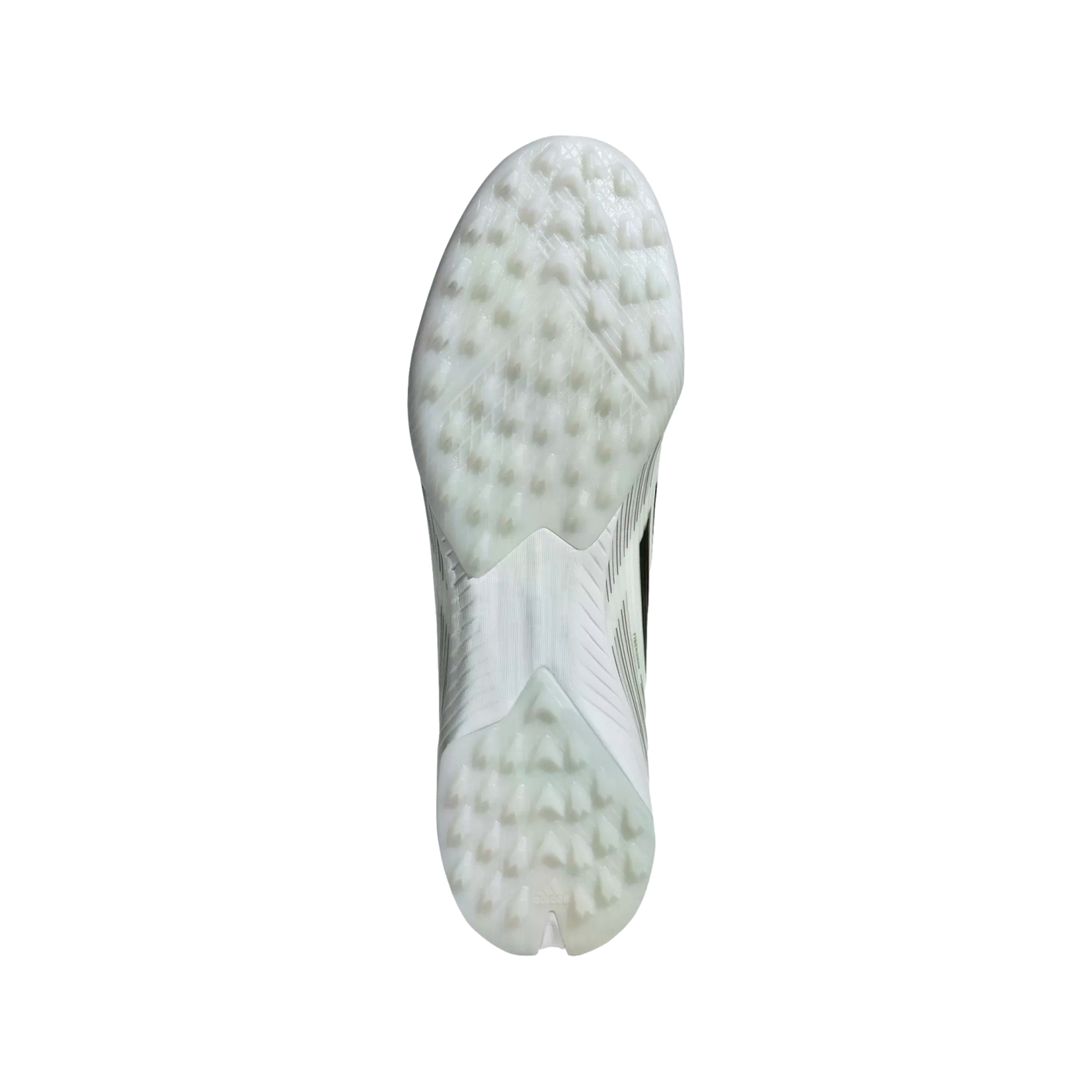 The white and translucent studded outsole of a soccer shoe, featuring a pattern of small triangular cleats designed for traction.
