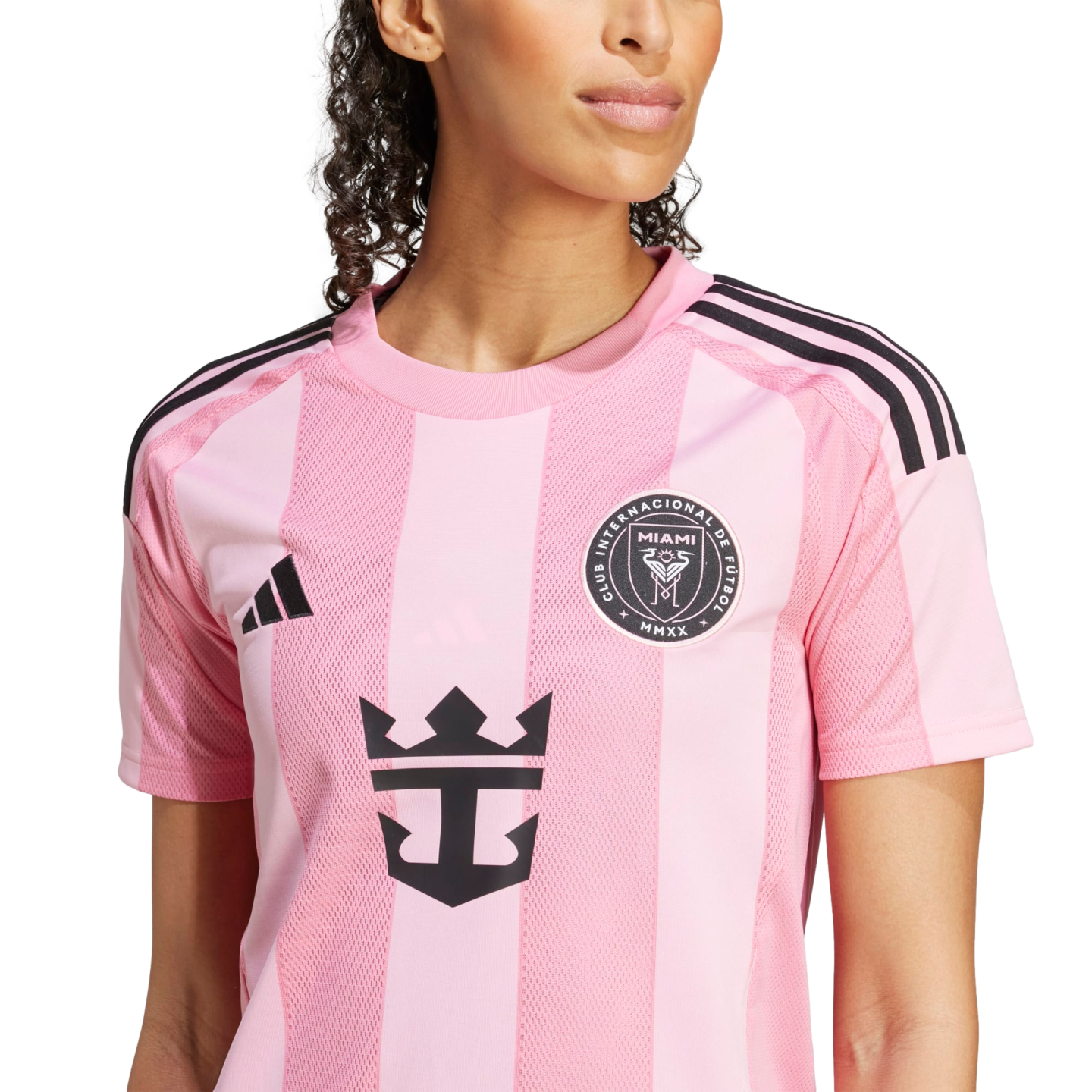 A woman wearing a pink Inter Miami CF soccer jersey featuring the team crest, Adidas logo, and Royal Caribbean sponsorship logo on the front.