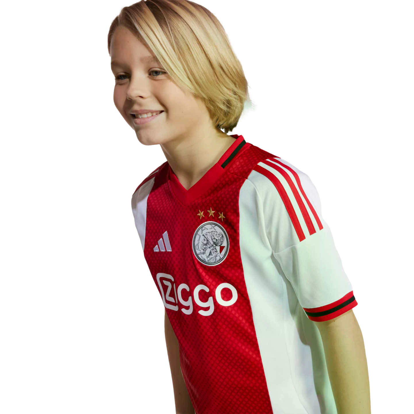 A smiling blonde child wearing a red and white Ajax football jersey.