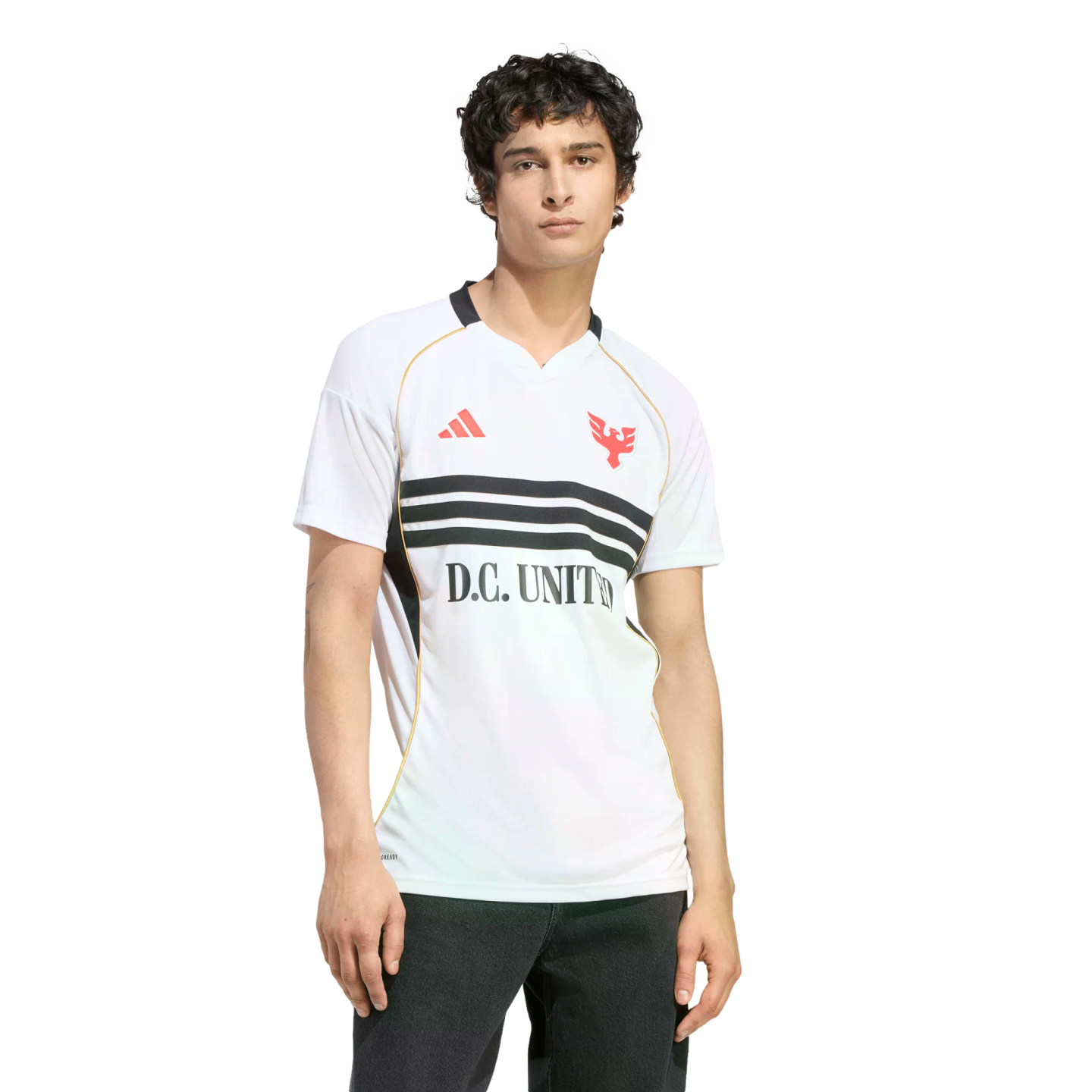 A man with dark curly hair wearing a white D.C. United soccer jersey with three black horizontal stripes across the chest, posing against a solid black background.