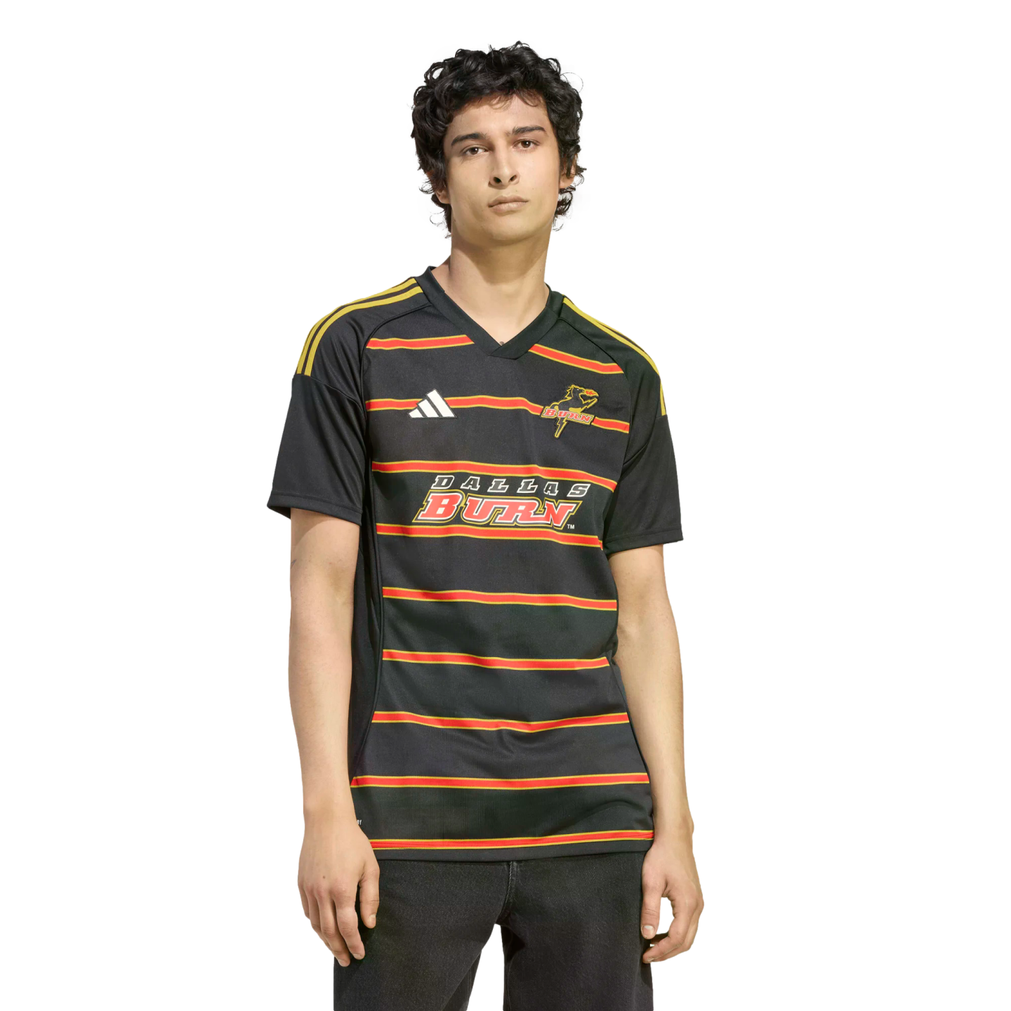 A man wears a black Dallas Burn soccer jersey with red and gold stripes and logos, set against a solid black background.