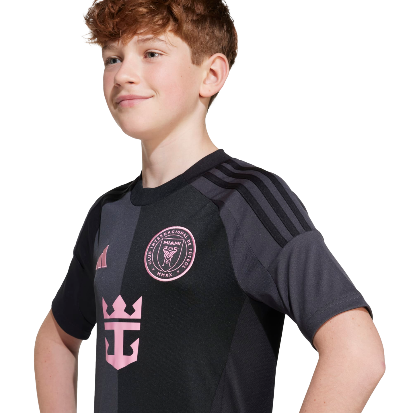 A young person with wavy reddish-brown hair wears a black and grey Inter Miami soccer jersey featuring a pink team crest and Royal Caribbean logo.